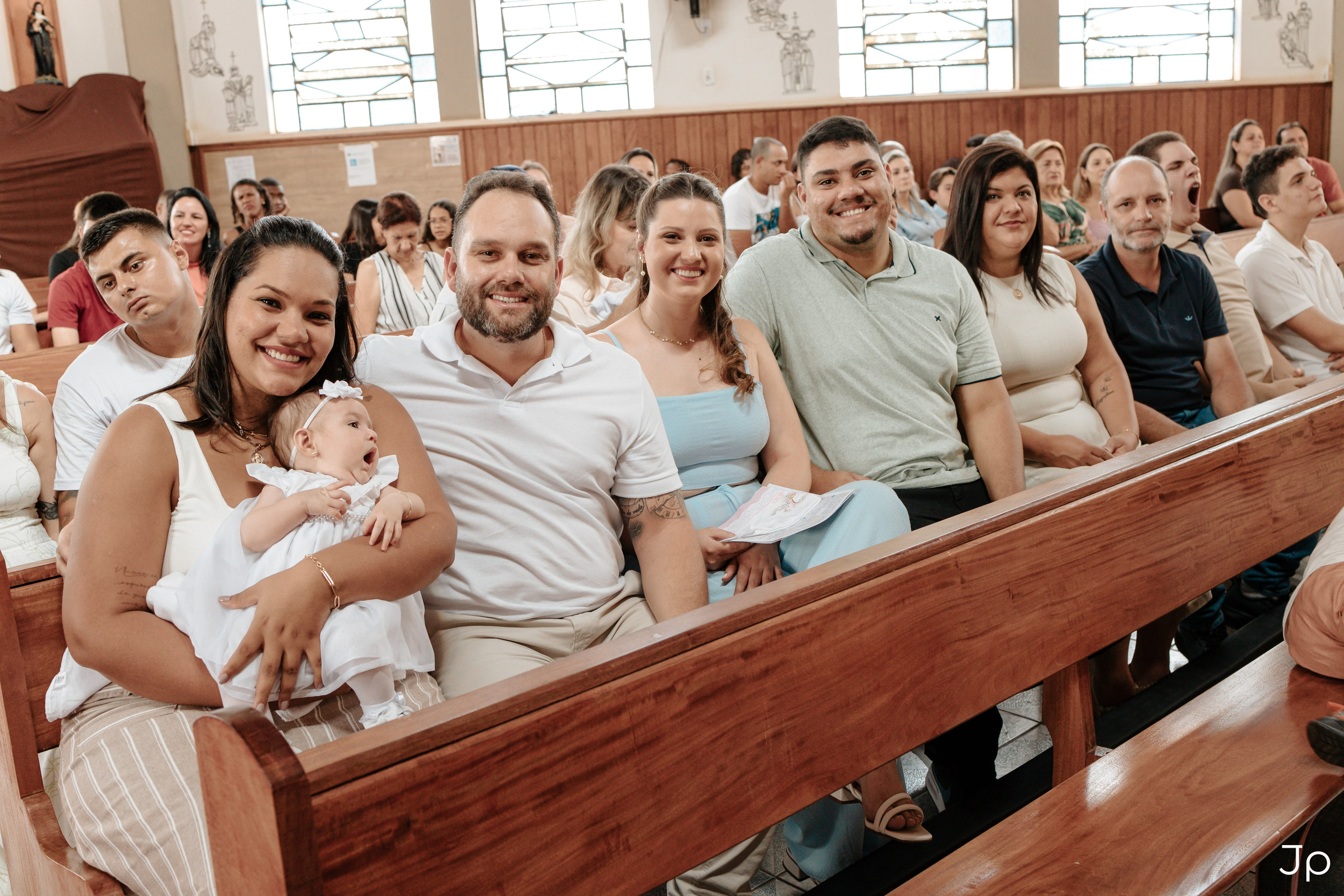 Convidados sentados nos bancos, acompanhando a celebração na Igreja em Bariri.