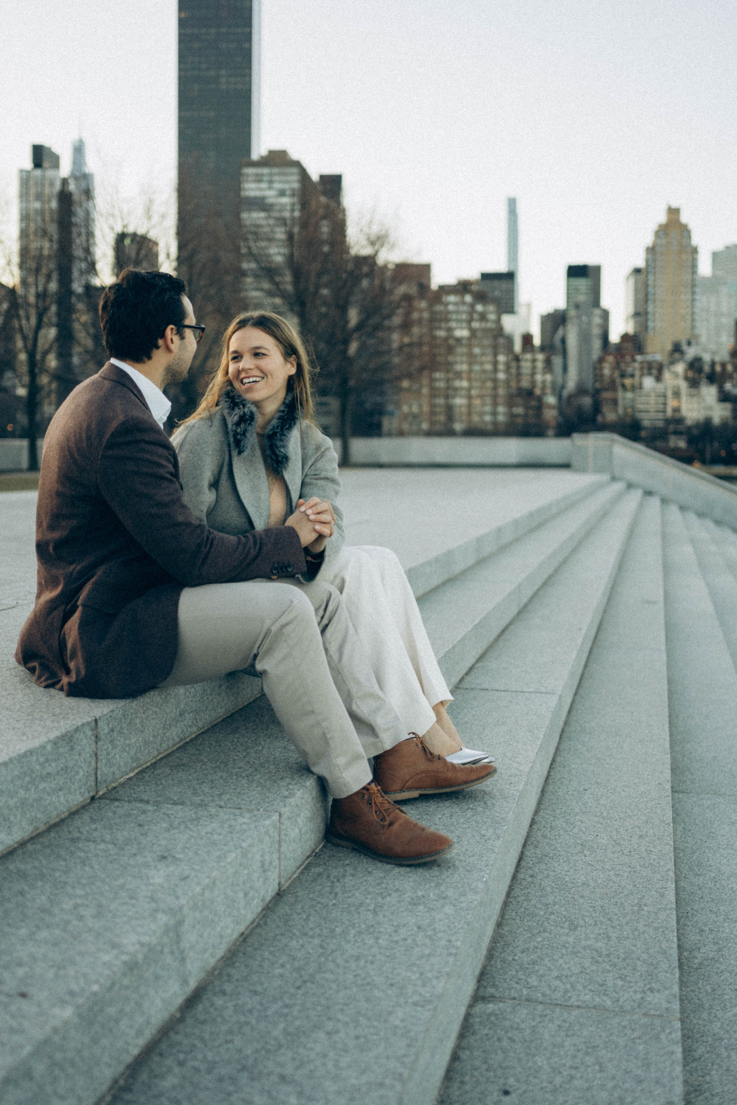 Couple hugging on Brooklyn Bridge sunset background.