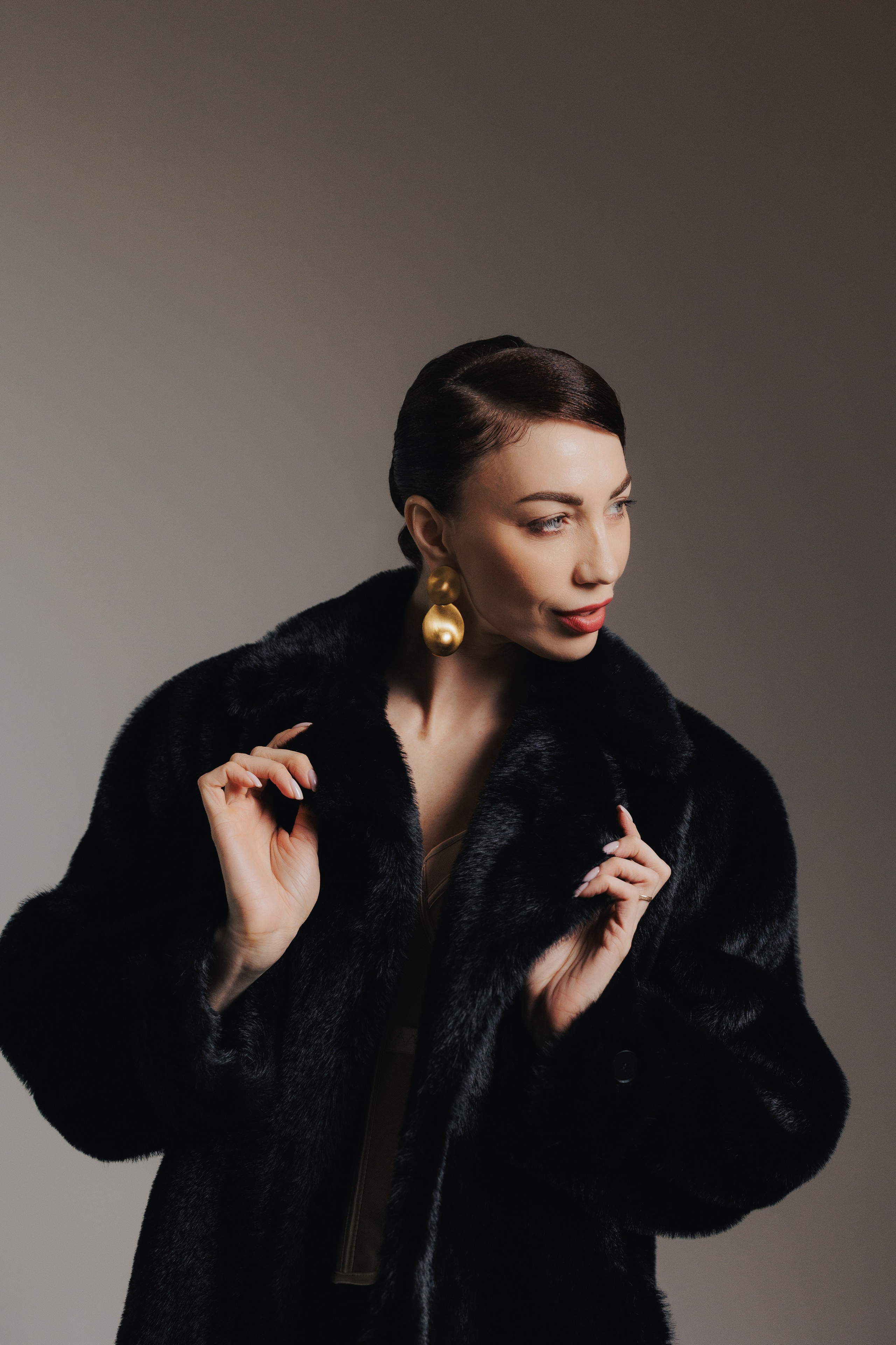 Modern editorial studio portrait of a woman in a black fur coat with minimalist styling and elegant pose, photographed in Leipzig, Germany. Современный редакционный студийный портрет девушки в чёрной шубе с минималистичным стилем и элегантной позой, снятый в Лейпциге, Германия.
