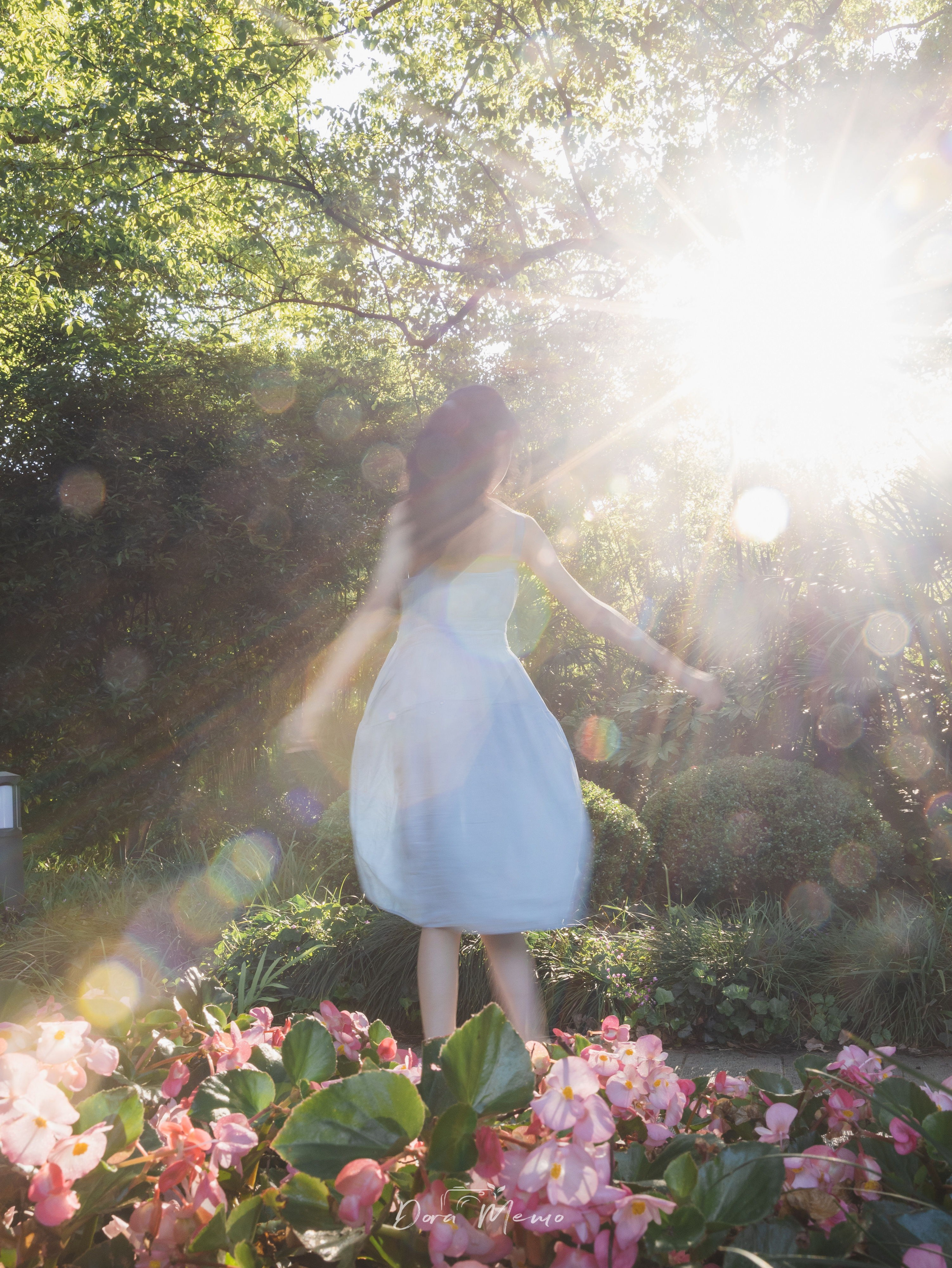 Arms open, back to camera, strong backlight flare | A girl opening her arms to the light, back to camera, lens flare