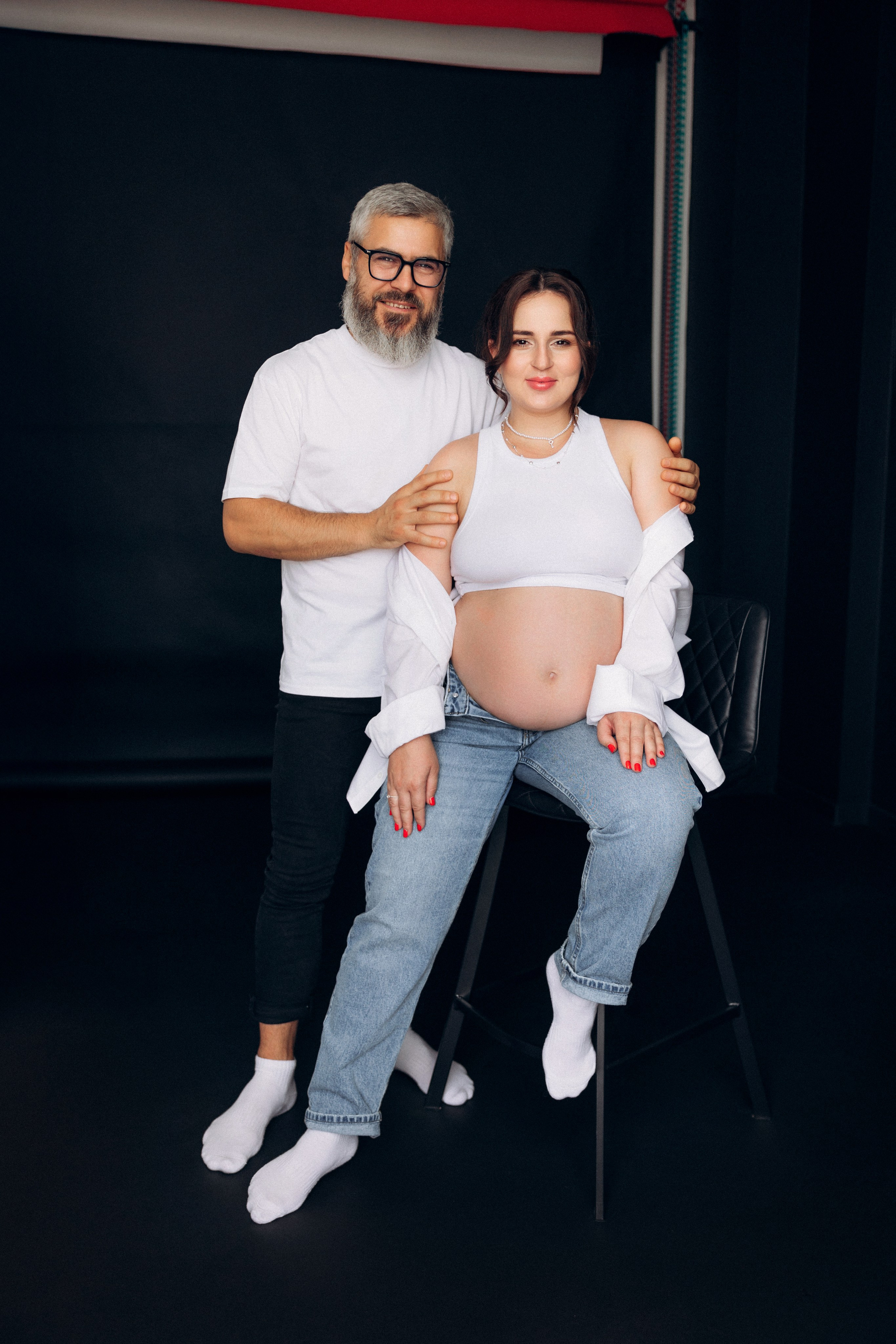 Intymna sesja ciążowa dla par – partnerzy patrzą sobie w oczy, bliskość i zaufanie w kadrze. Intimate couple maternity session – partners looking into each other’s eyes, closeness and trust captured.