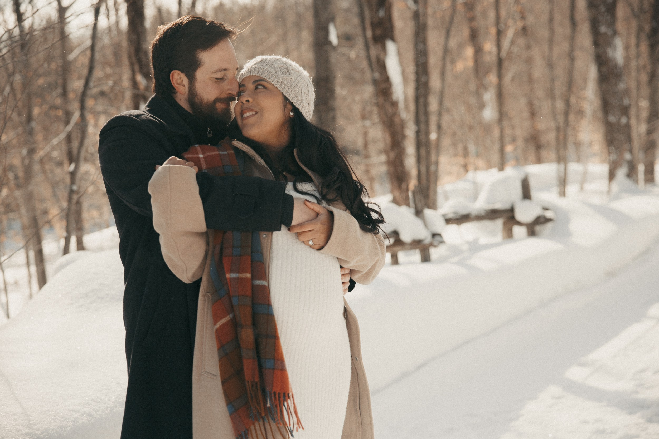 Pregnant couple embracing during winter session in Laval