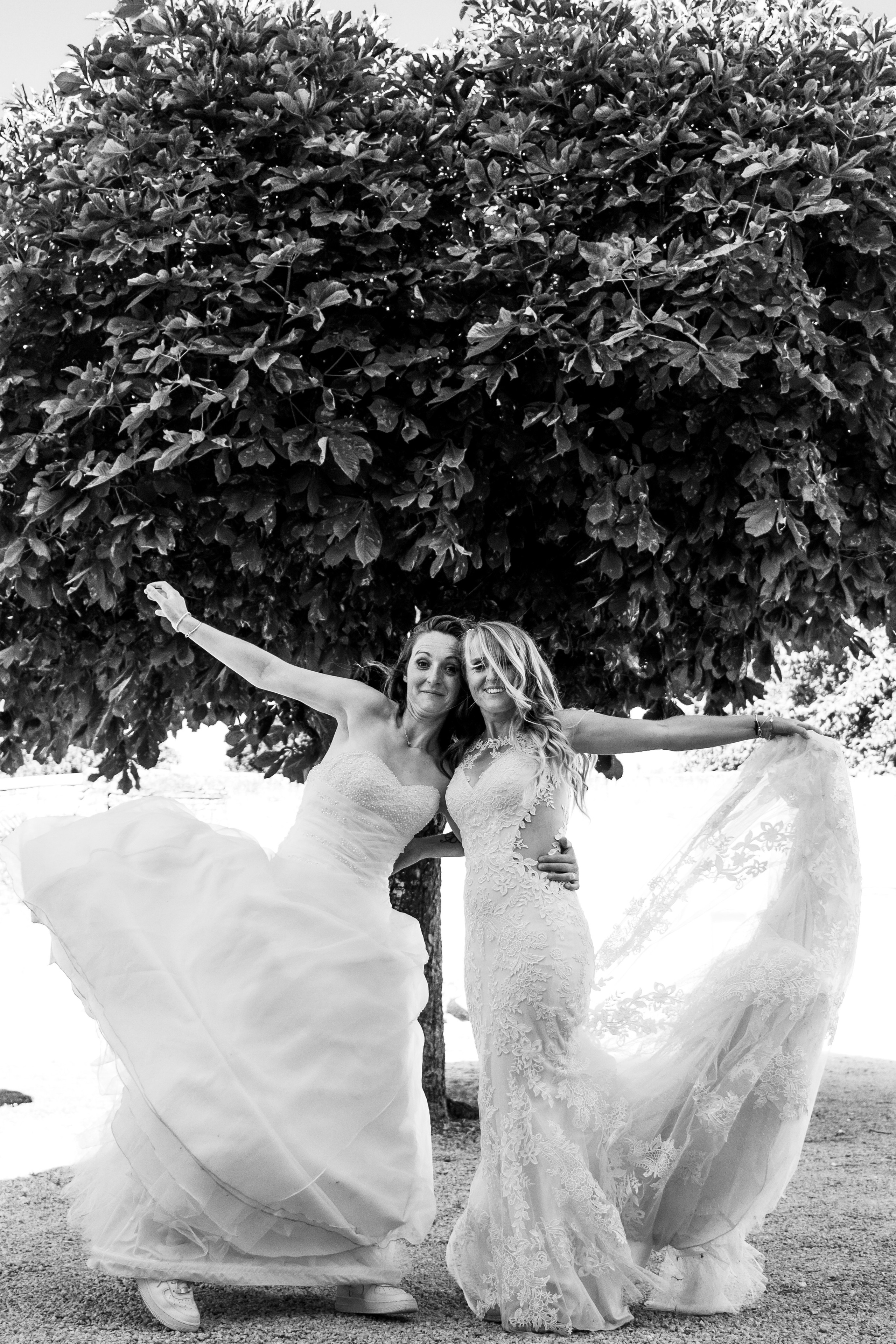 Deux femmes en robes de mariées se tenant la main, reportage photo de mariage inclusif