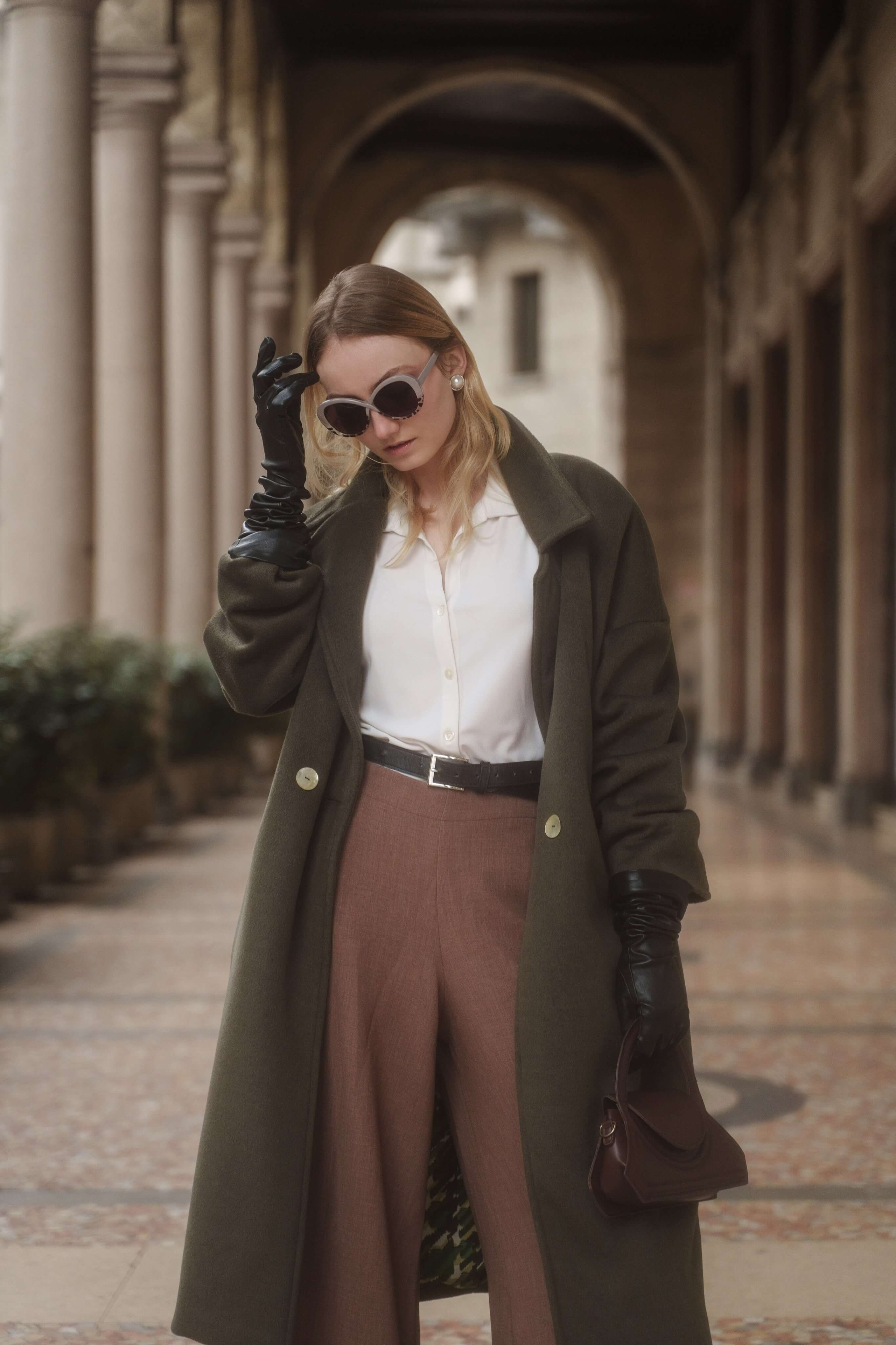 Location fashion shoot Milan – woman in designer sunglasses under architectural arcade