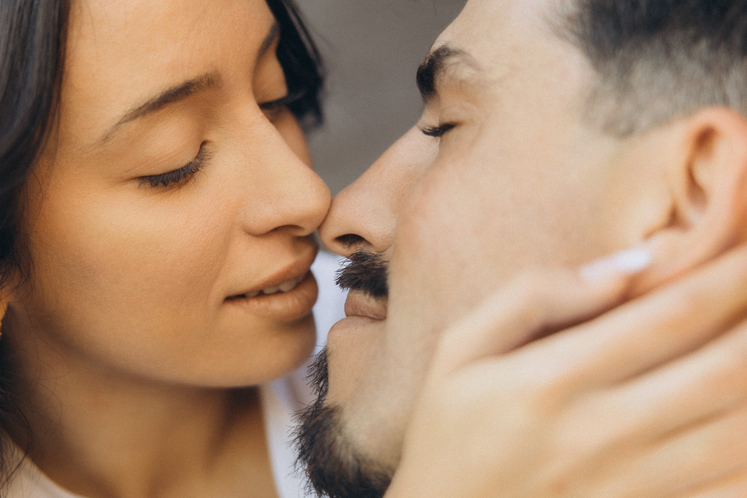 Couple sharing a romantic moment during sunset on Madeira Island, with the ocean and cliffs in the background