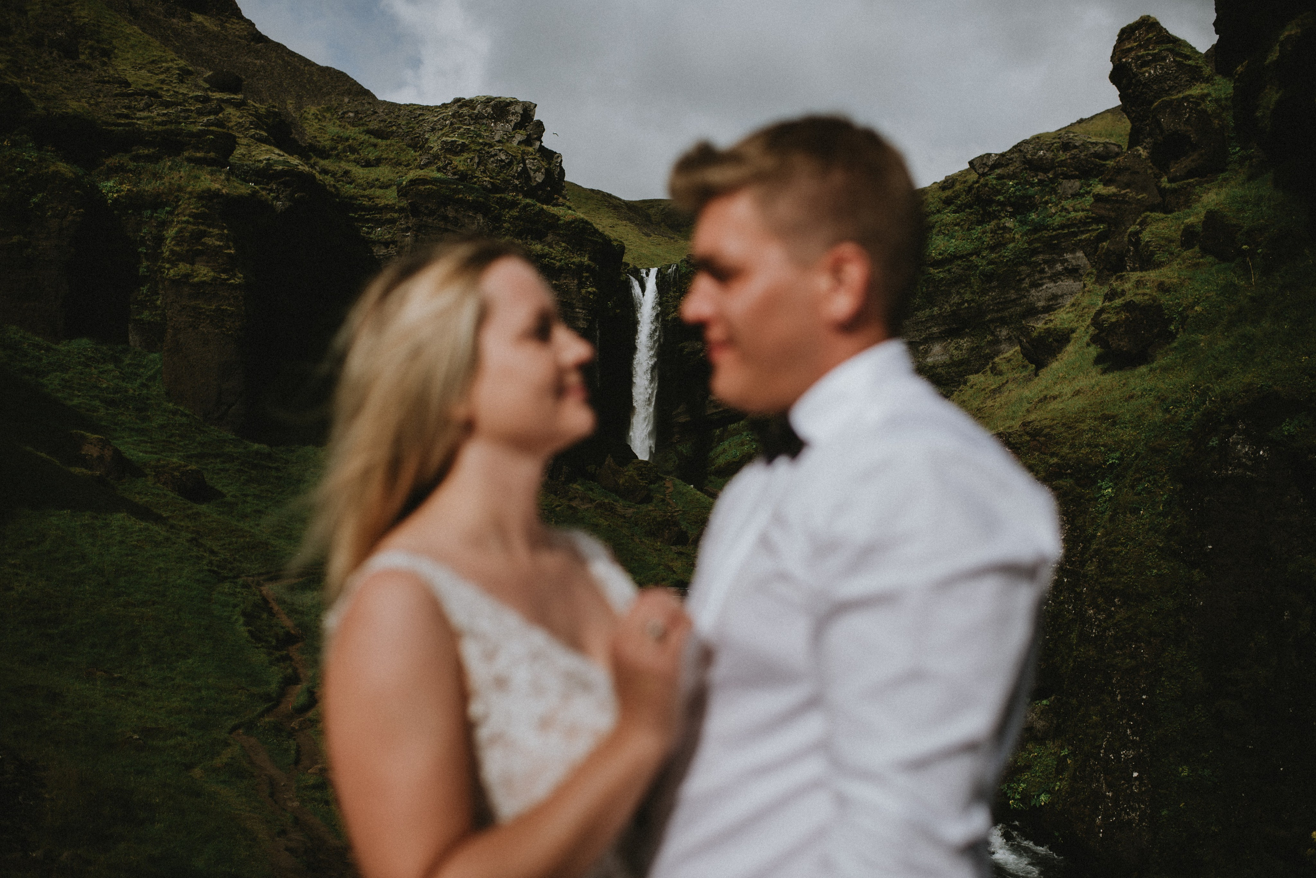 Eloping couple exploring the lush green canyon near Kvernufoss, surrounded by untouched Icelandic nature.