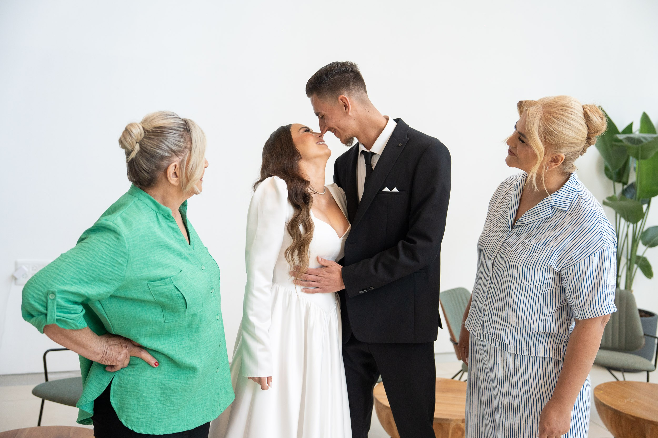 Bride Lin and groom Garik sharing a romantic look with their mothers watching during the first look in Netanya, Israel