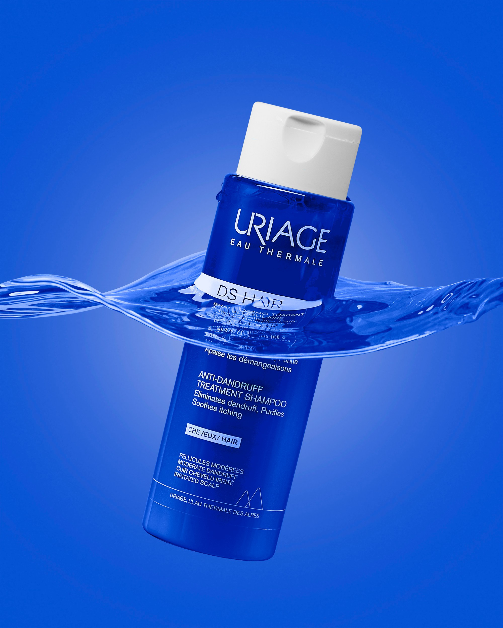Photographer Roman Djuzev - Photo of a bottle of Uriage shampoo in water on a blue background.