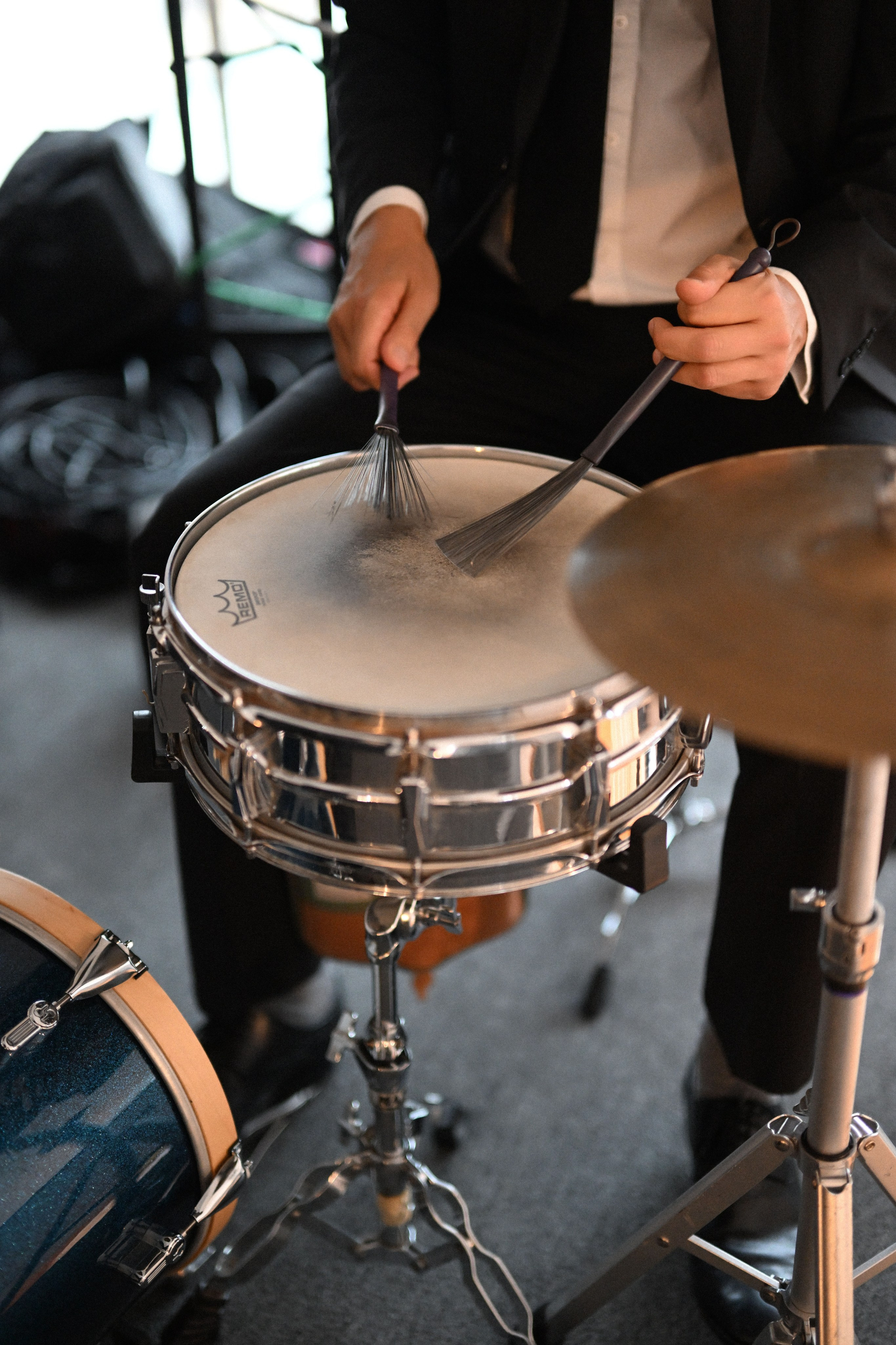 a man in a suit playing a drum