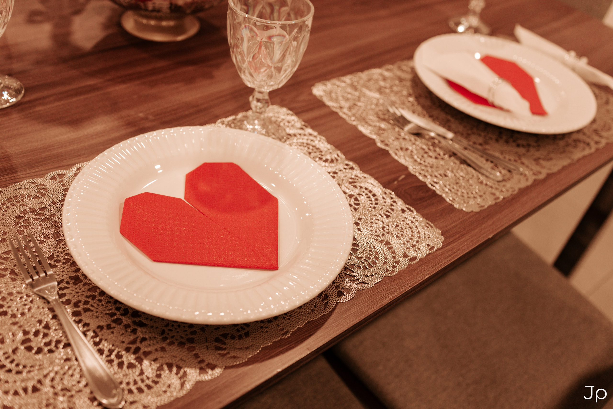 Prato com guardanapo em formato de coração vermelho.