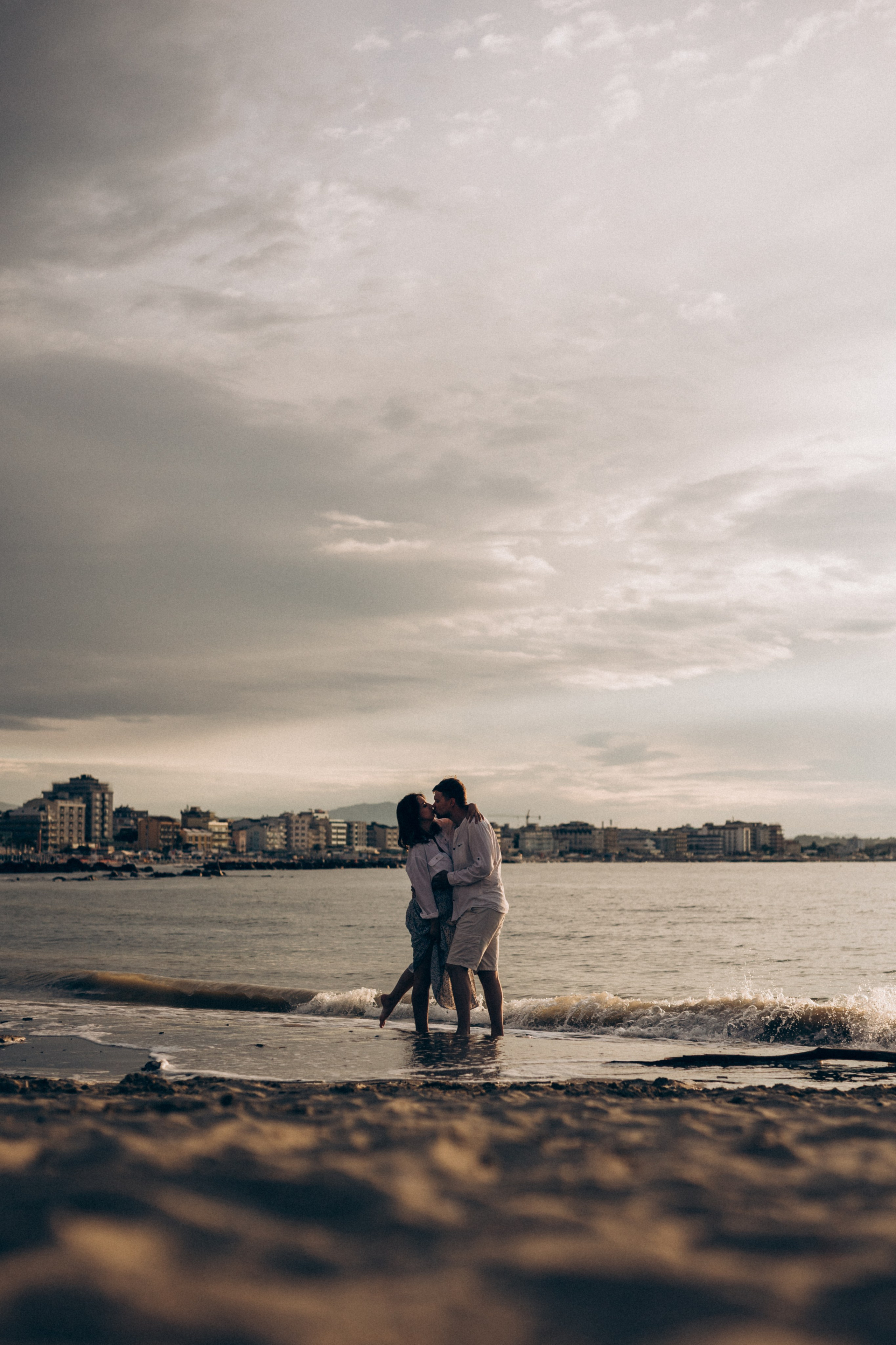 coppia che si bacia sul mare durante un servizio fotografico romantico a Rimini