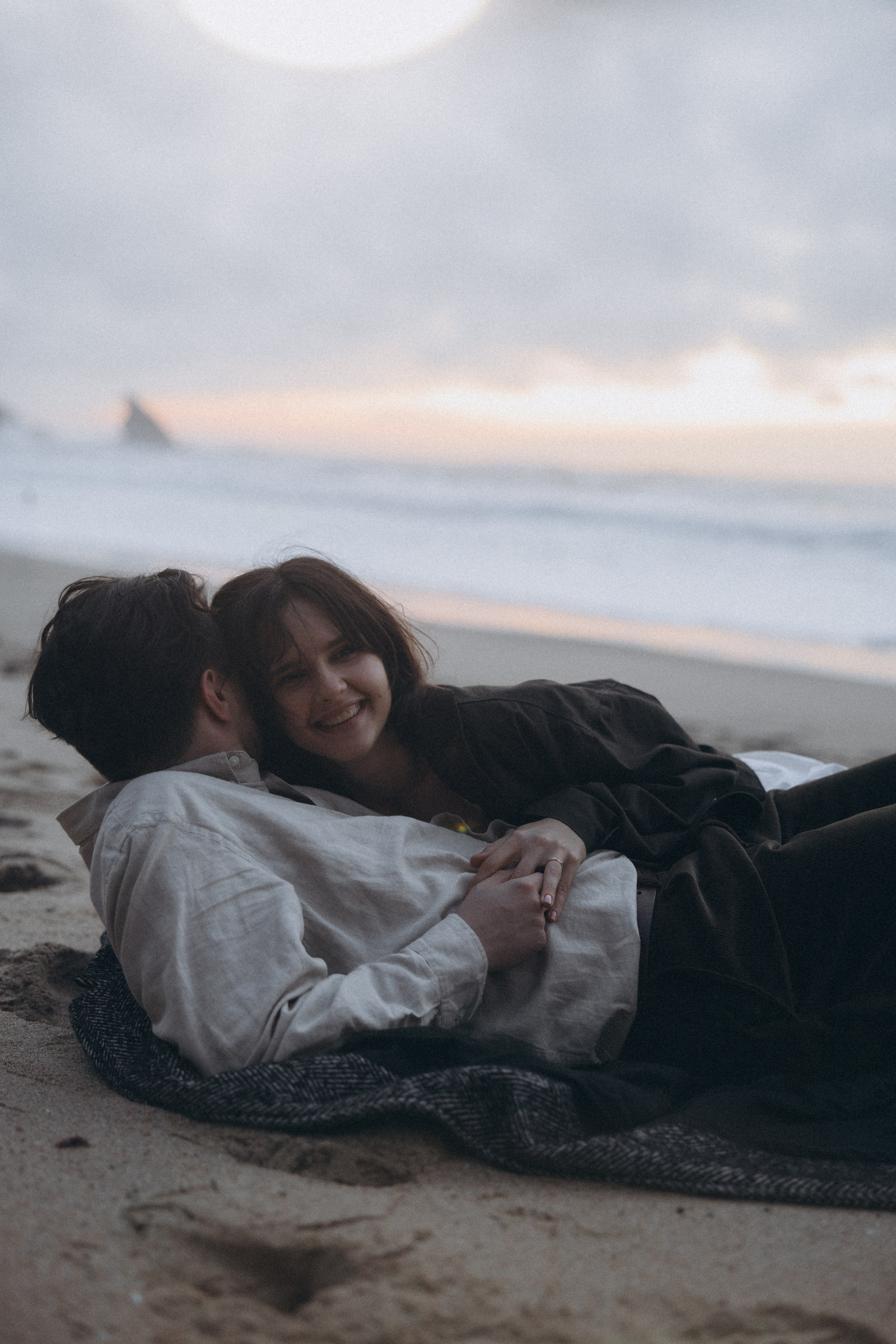 Couple holding hands and walking through a picturesque coastline in Portugal.