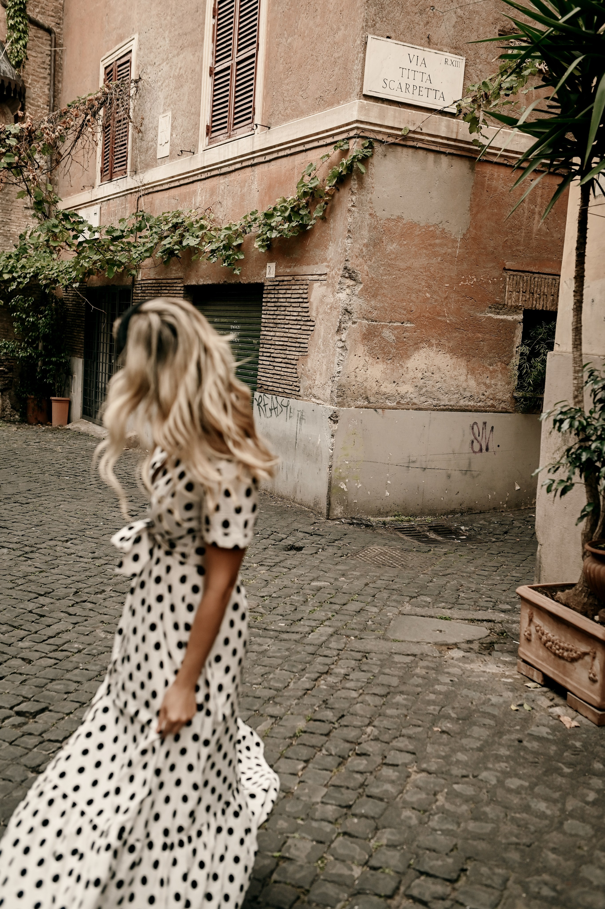 A candid moment as a woman walks through a quiet Roman street