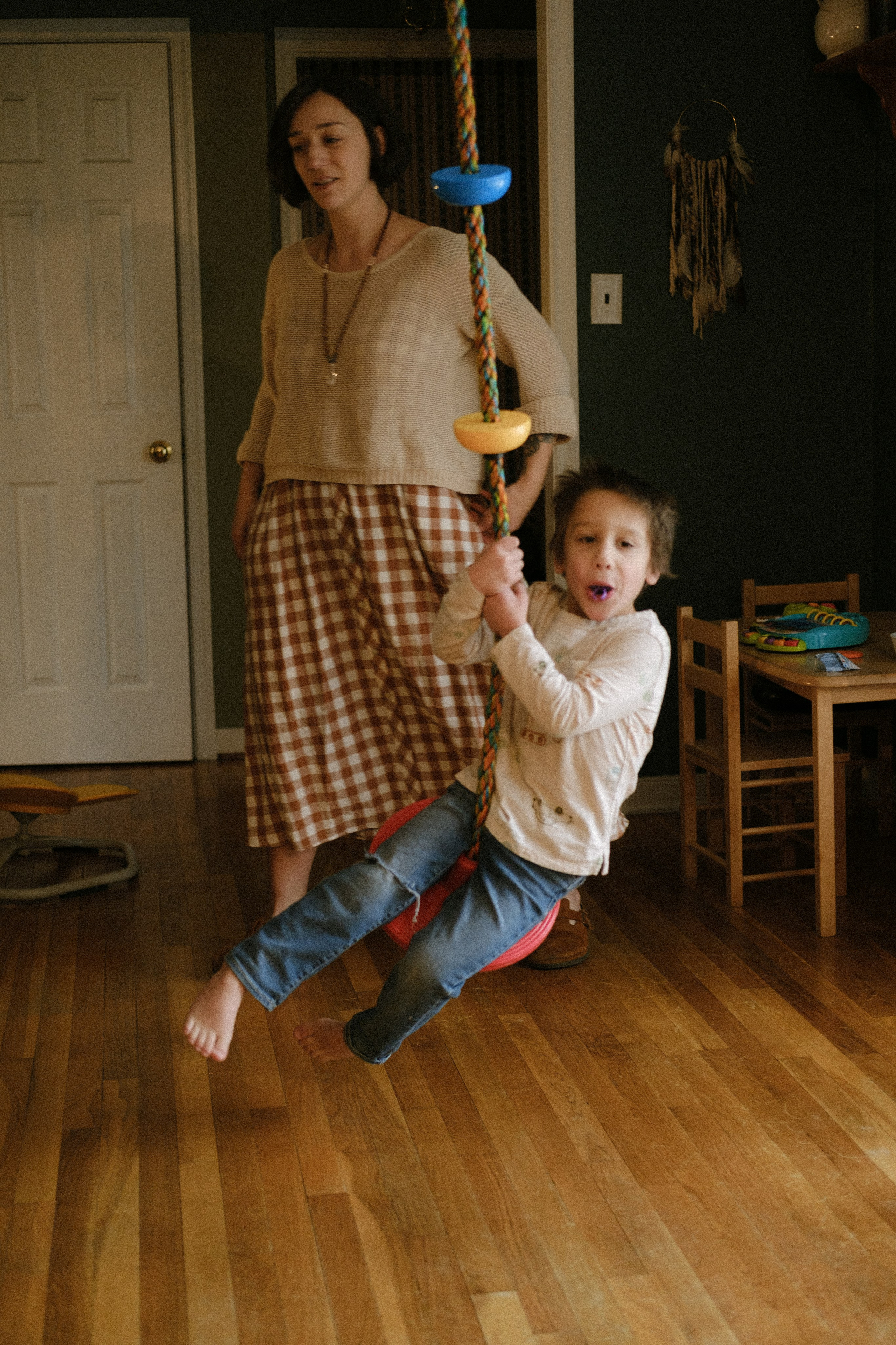 Neurodivergent twin boys enjoying an indoor swing during a home photoshoot