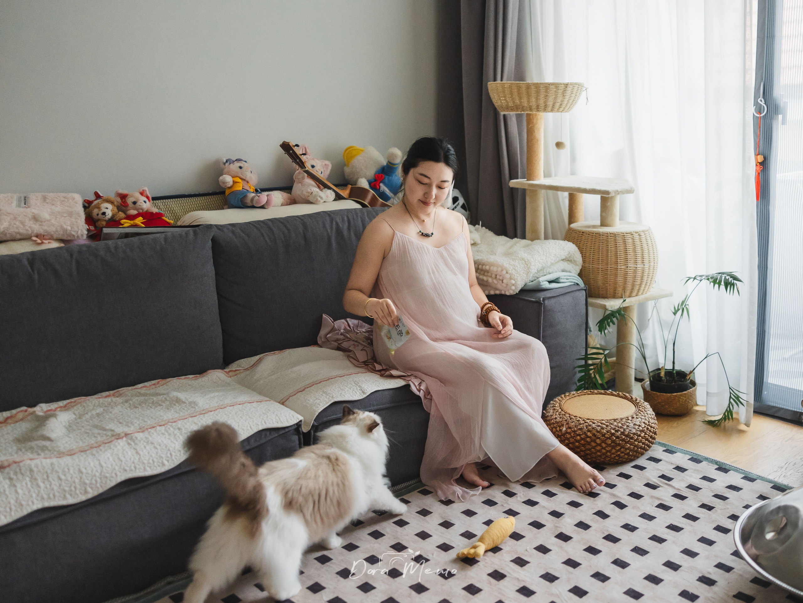 Pregnant woman relaxing at home with her cat, photographed by a Shanghai family photographer documenting family life before the baby arrives.