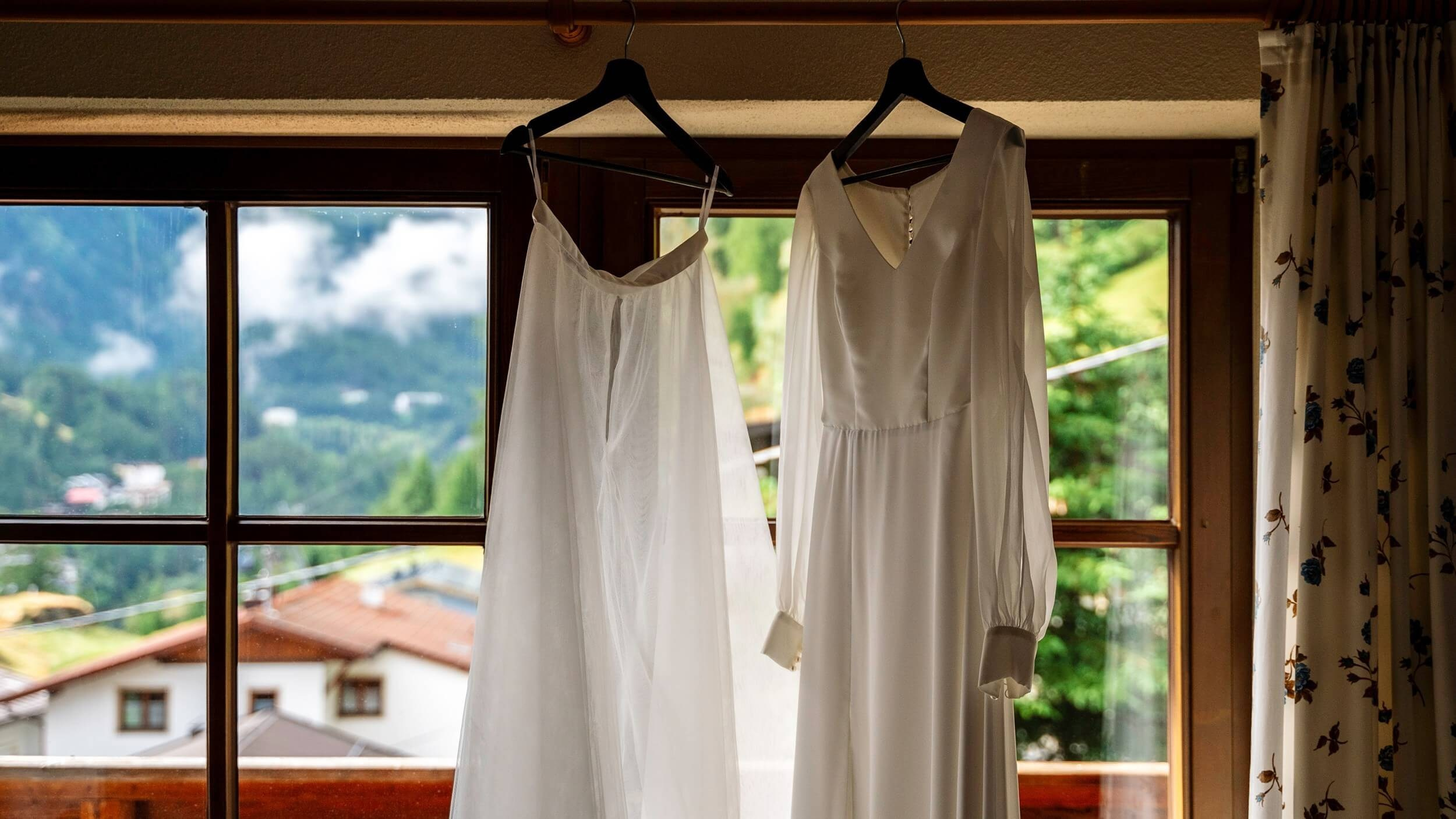 Hochzeitskleid im Fenster eines Chalets in den Tiroler Alpen.