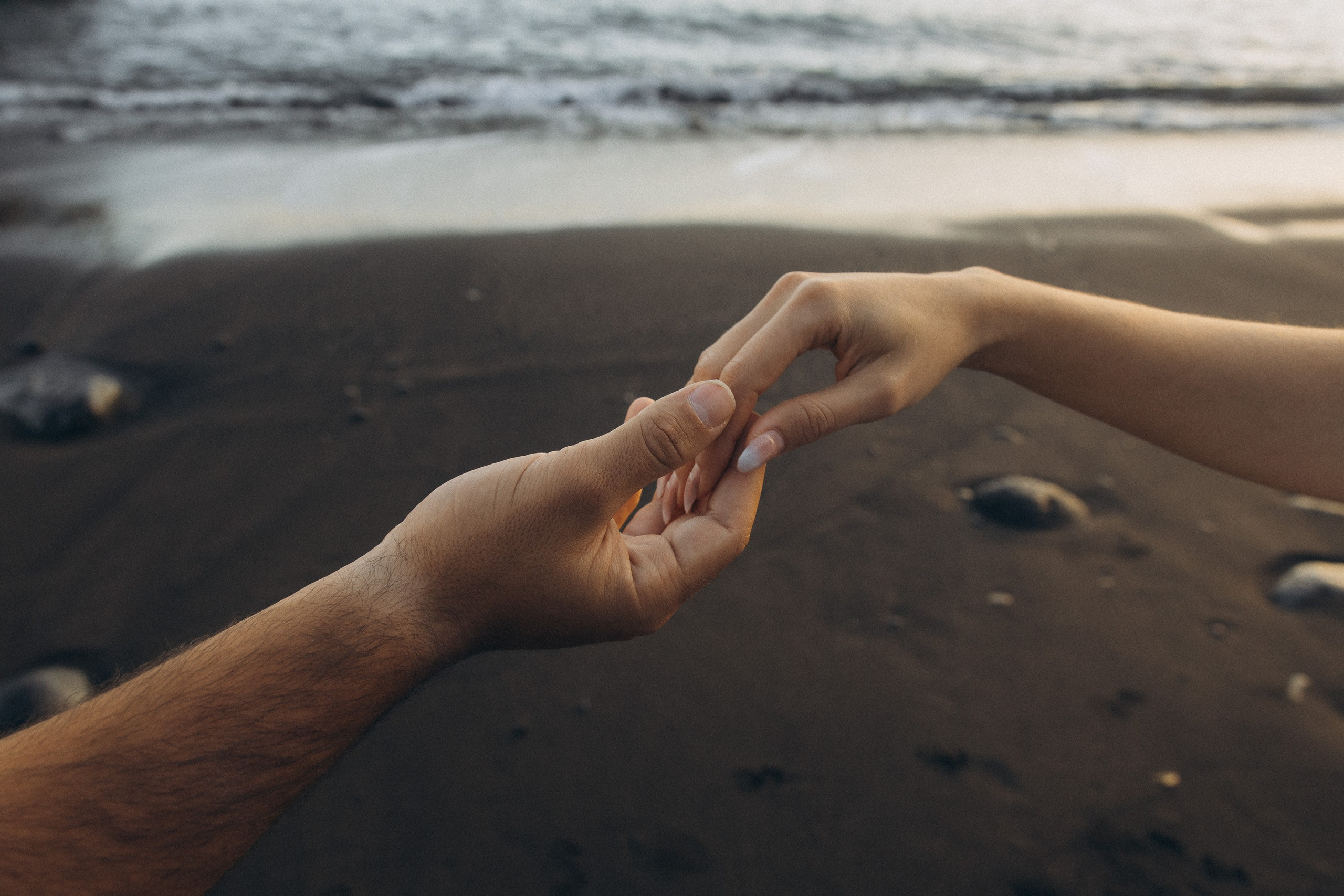 Couple sharing a romantic moment during sunset on Madeira Island, with the ocean and cliffs in the background