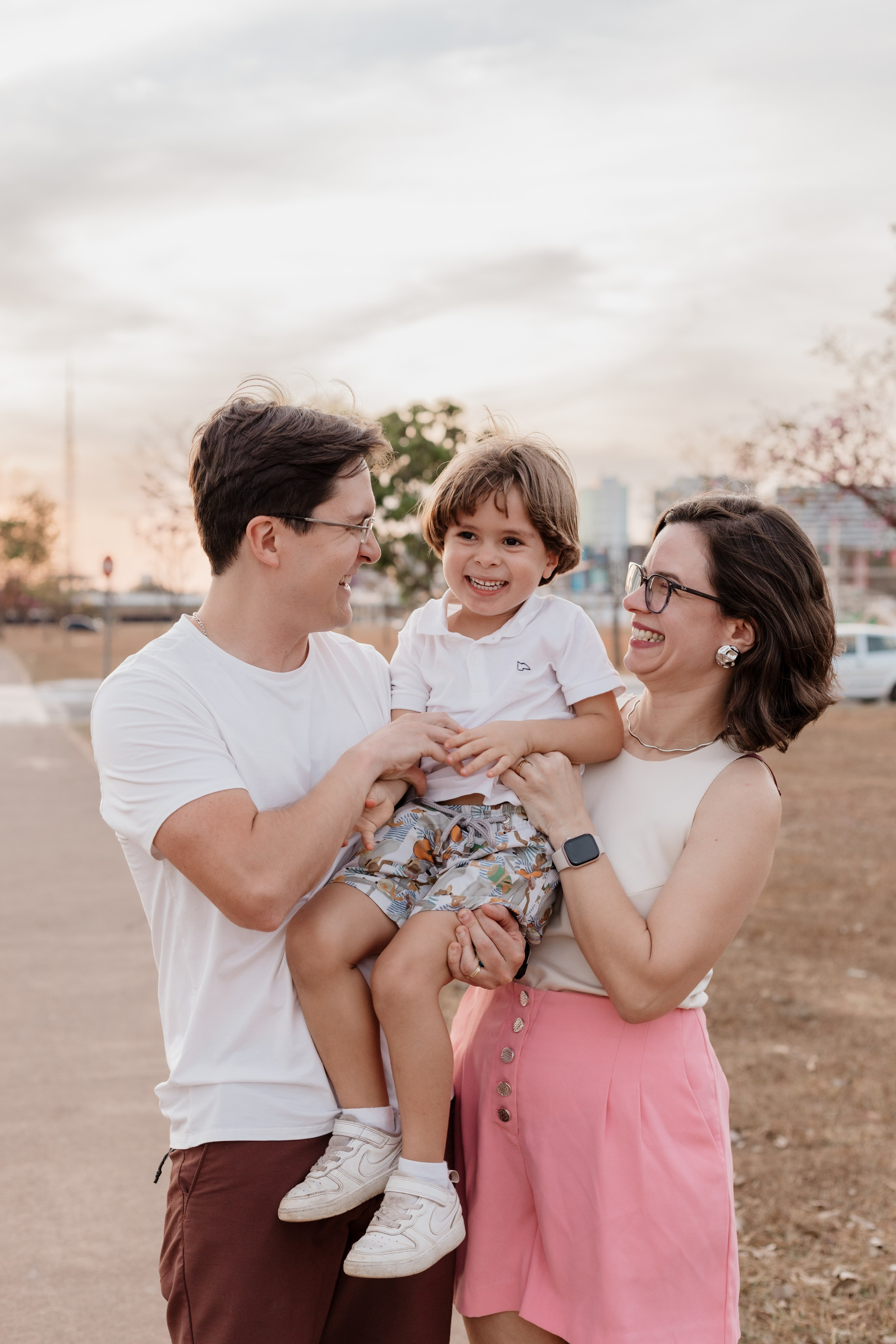 Família ao pôr do sol com menino sorrindo