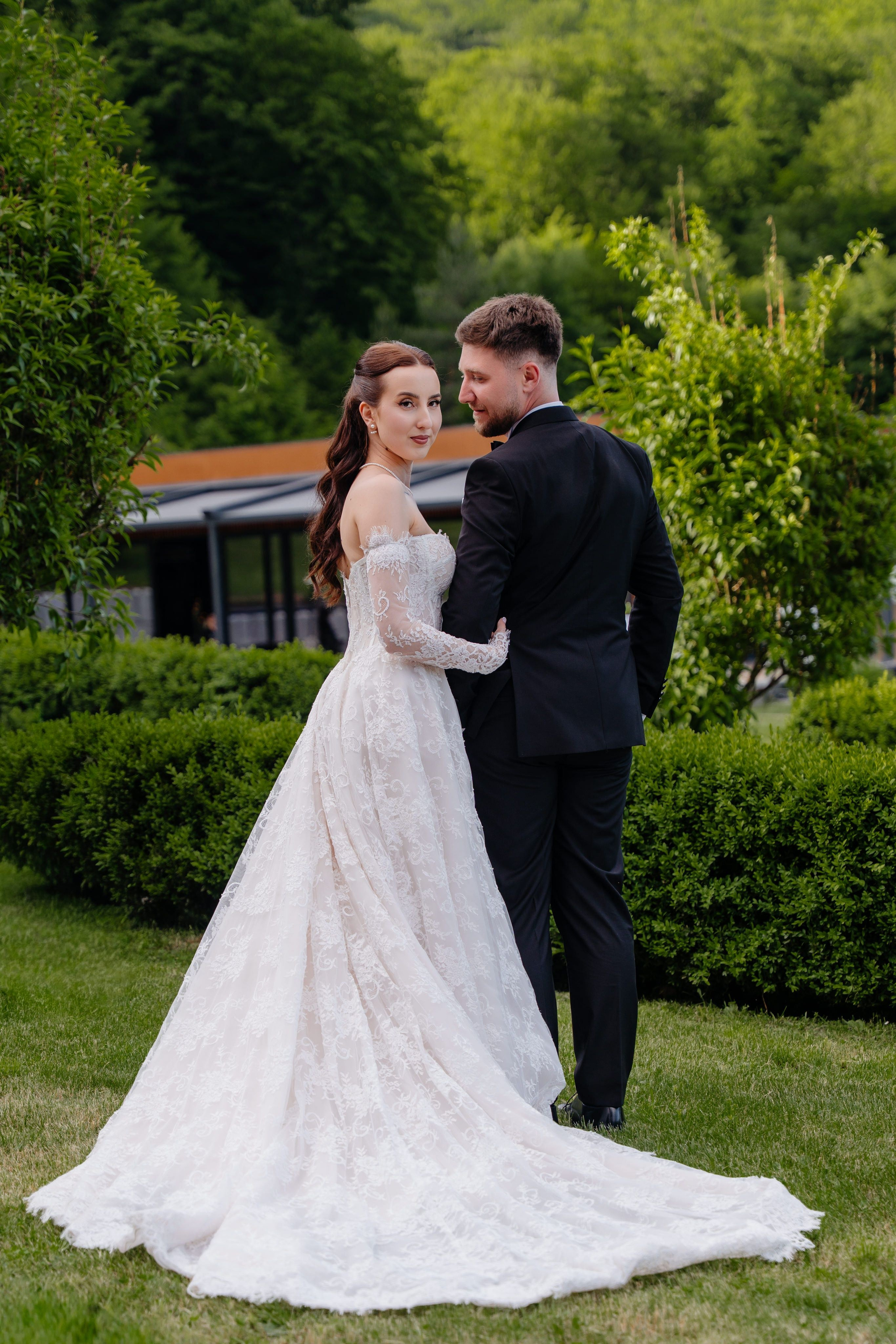 Fotografie de nunta cu spatele mirilor in curtea locatiei