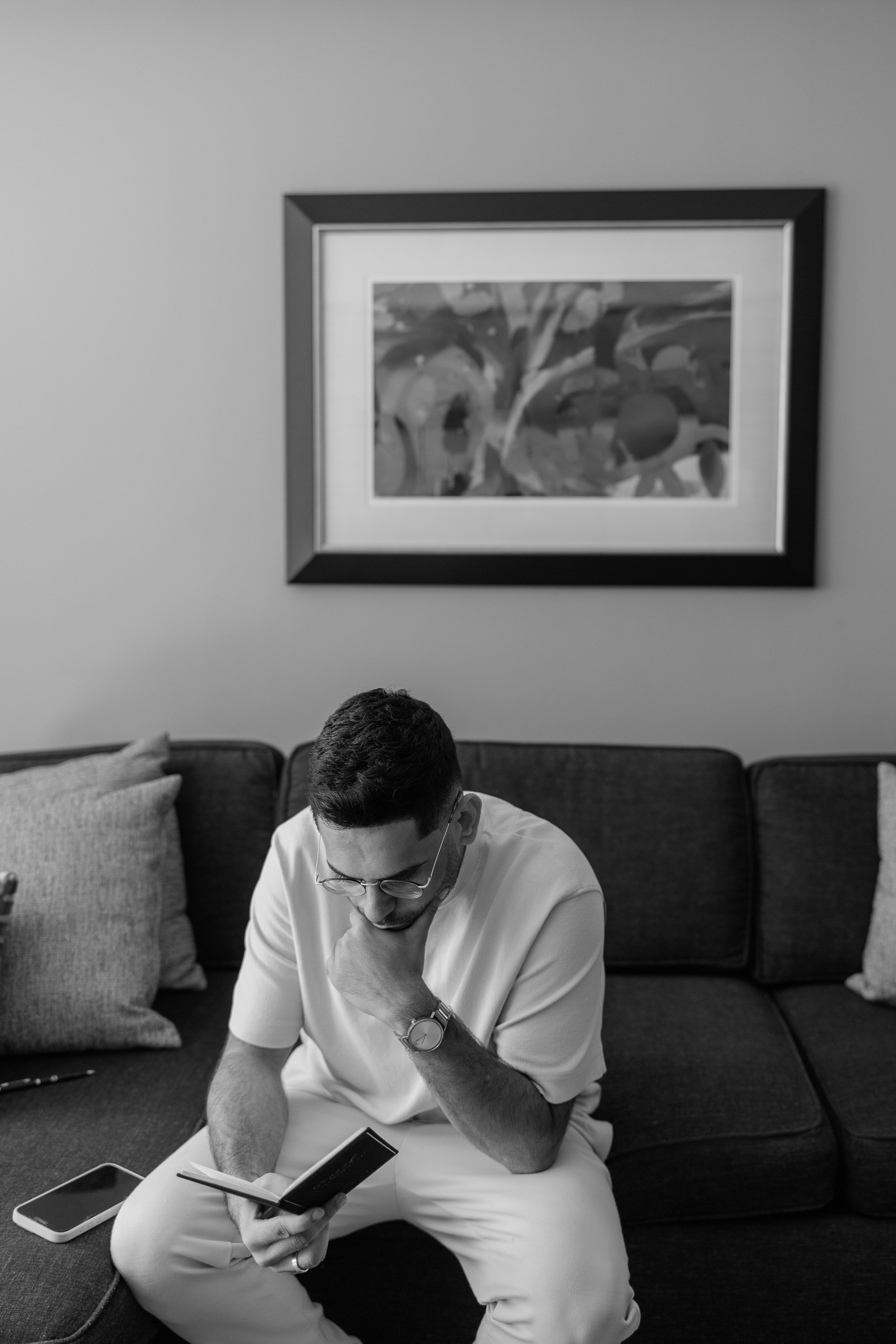 Groom sitting by the window during a quiet getting ready moment
