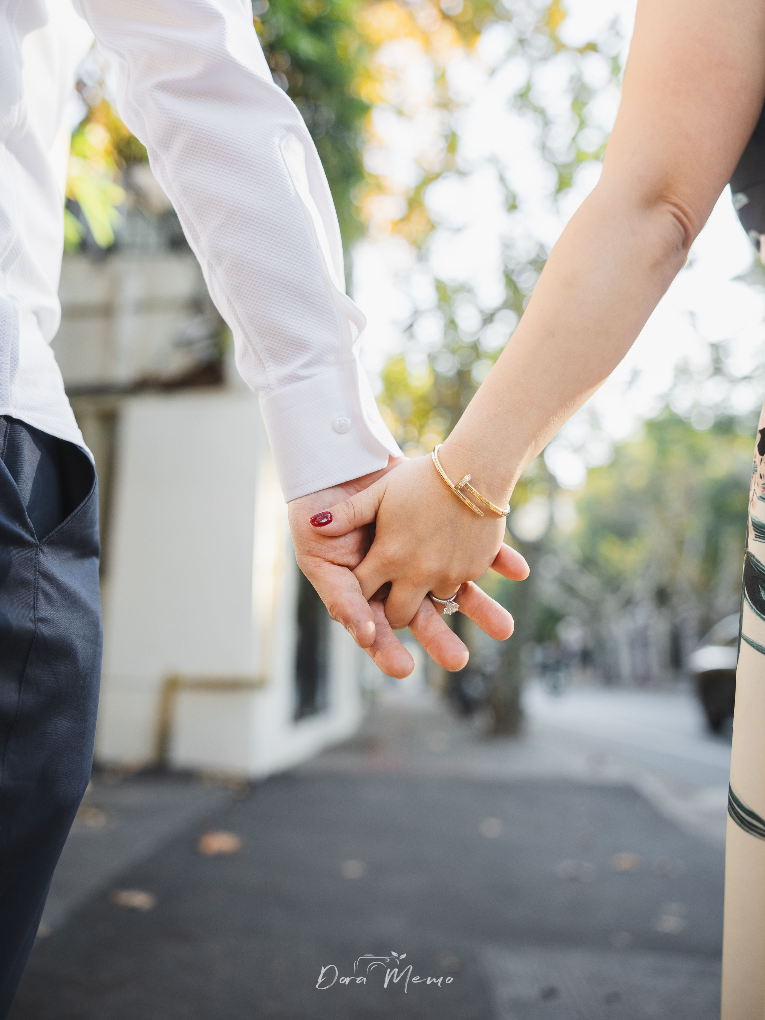 Close-up of intertwined hands showing the engagement ring