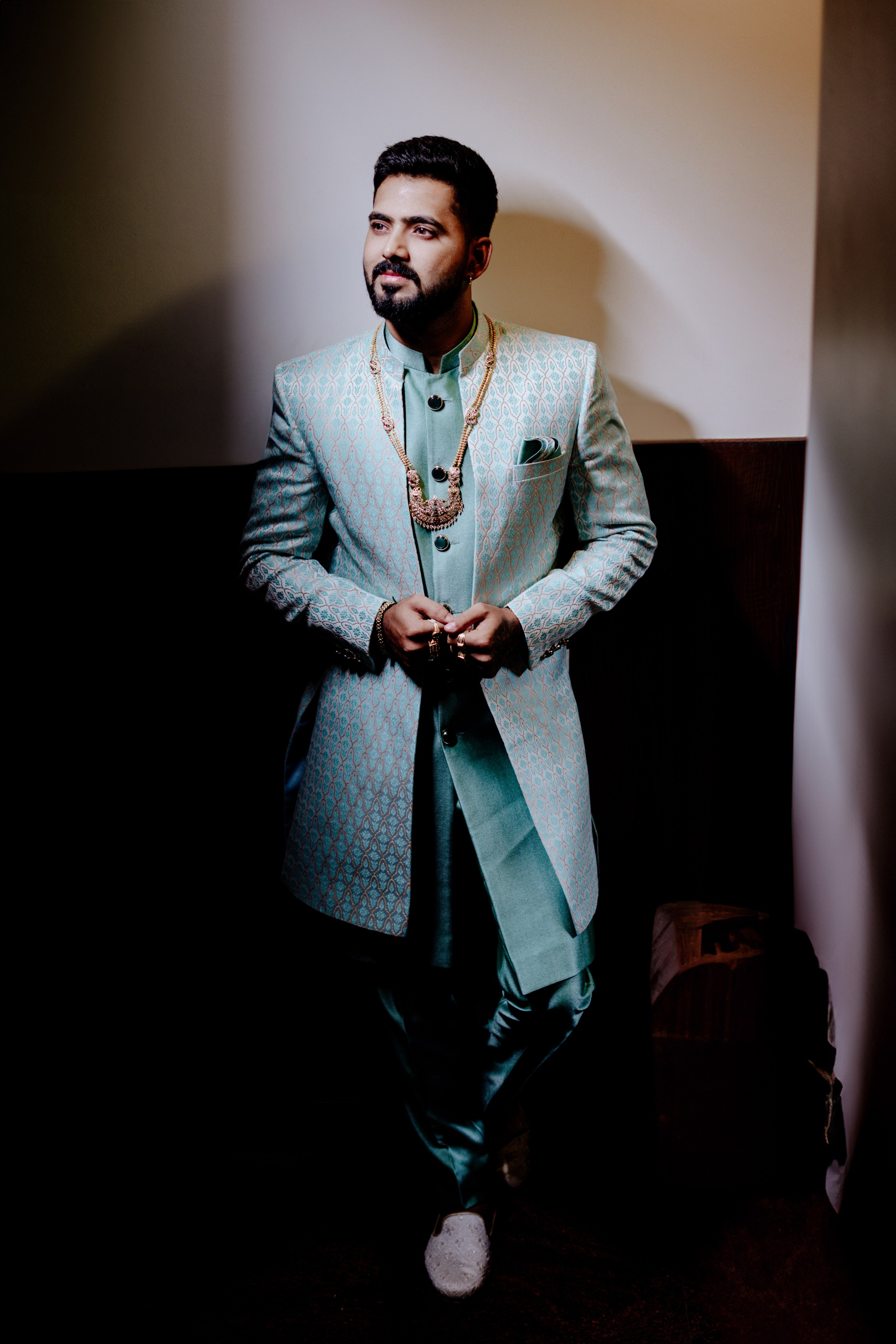 professional portrait of a groom wearing a light blue patterned sherwani and gold necklace for a wedding ceremony in Malleshwaram, Bengaluru