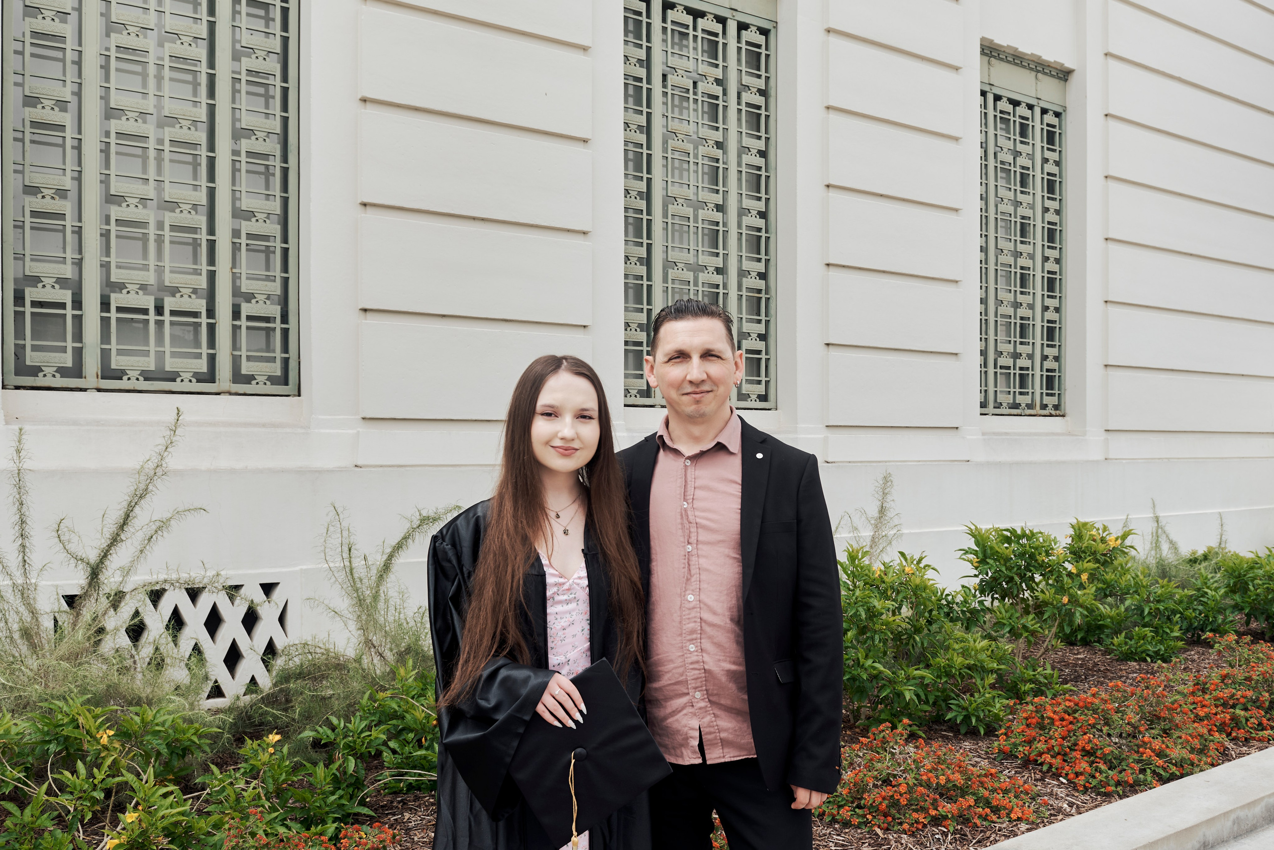 Graduate holding a ‘Class of 2024’ sign in front of a Los Angeles landmark