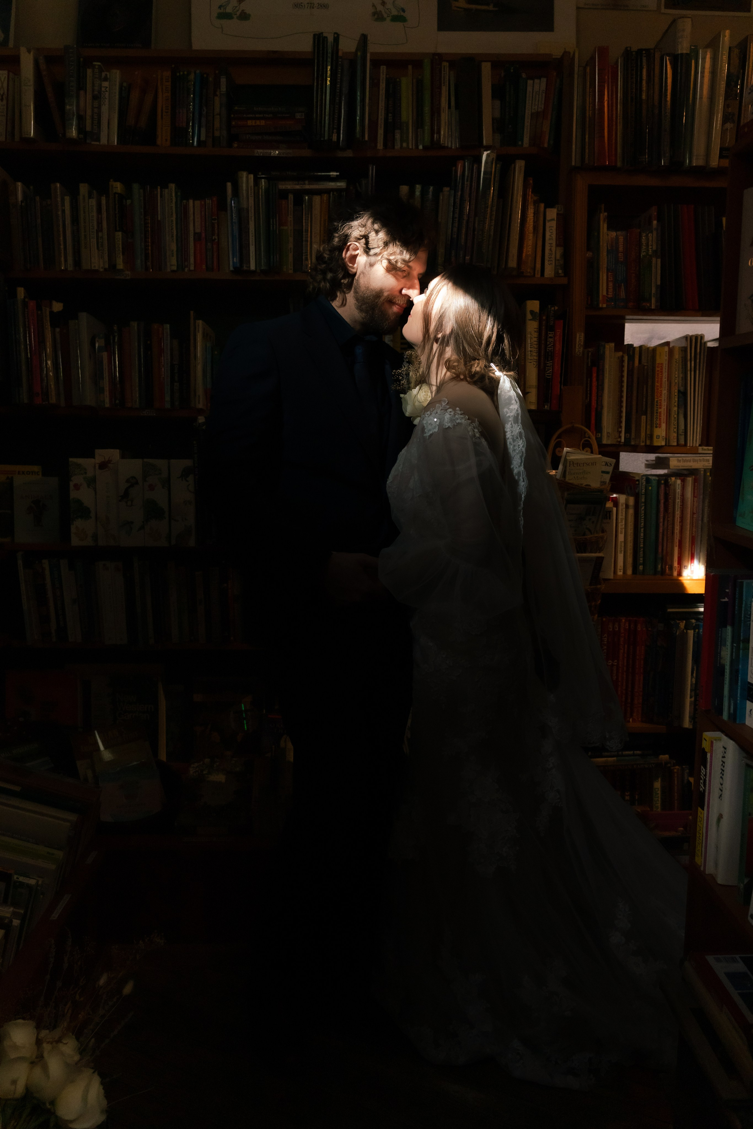 Artistic portrait of bride and groom in a book store in Morro Bay