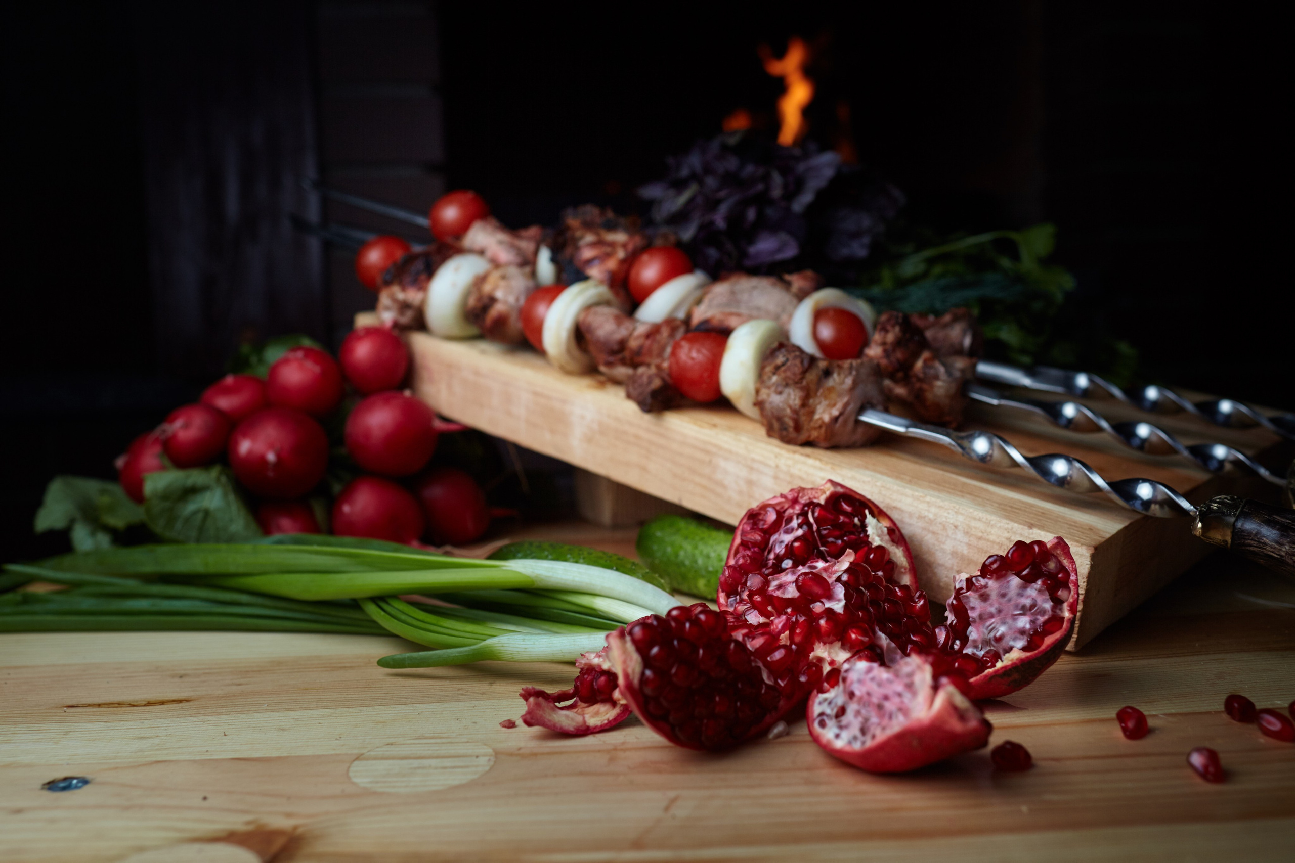 Photographie gastronomique de brochettes de viande et grenade sur fond rustique – mise en scène culinaire en Bourgogne