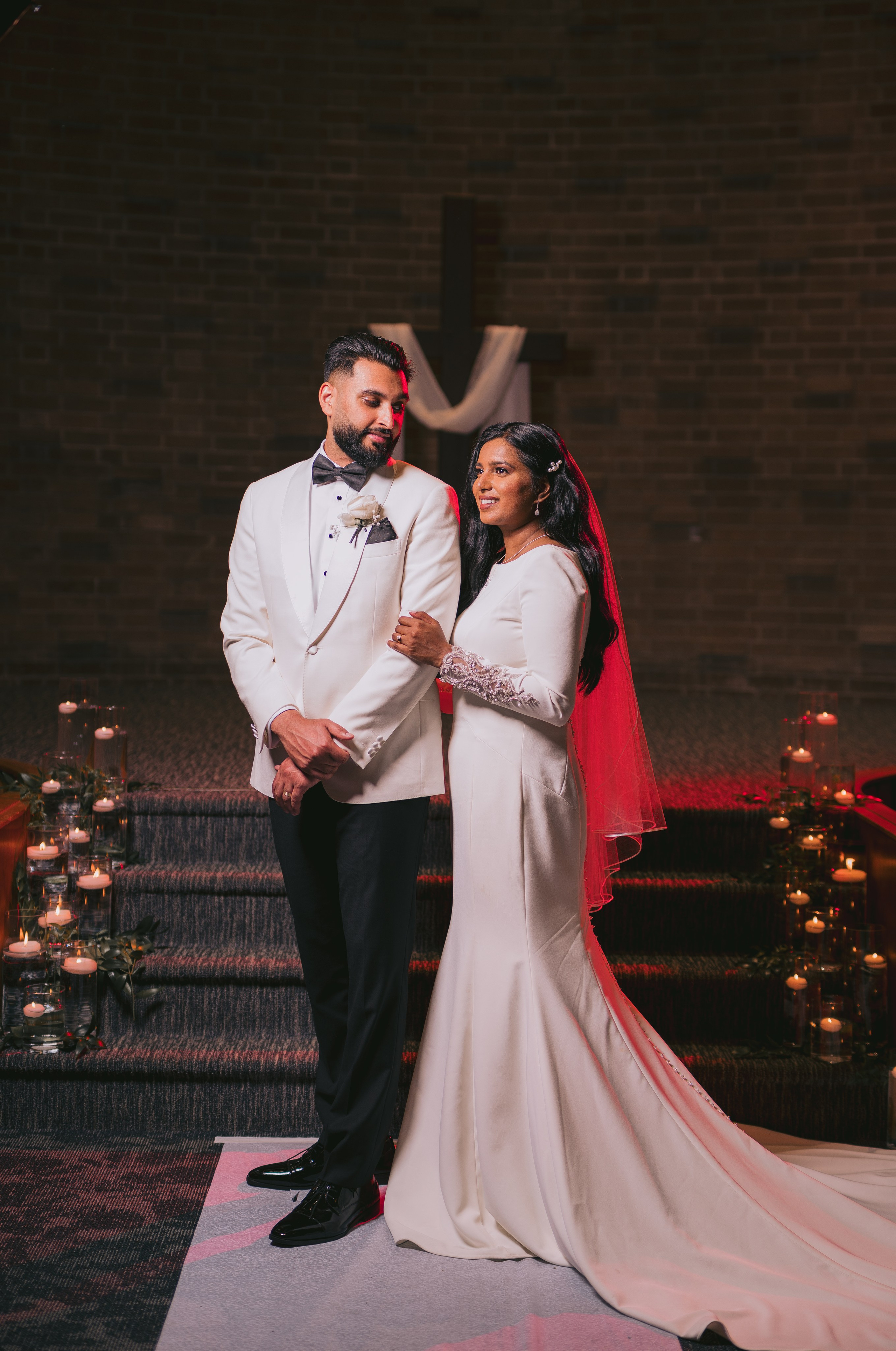 Bride and groom smiling under warm lights during evening event
