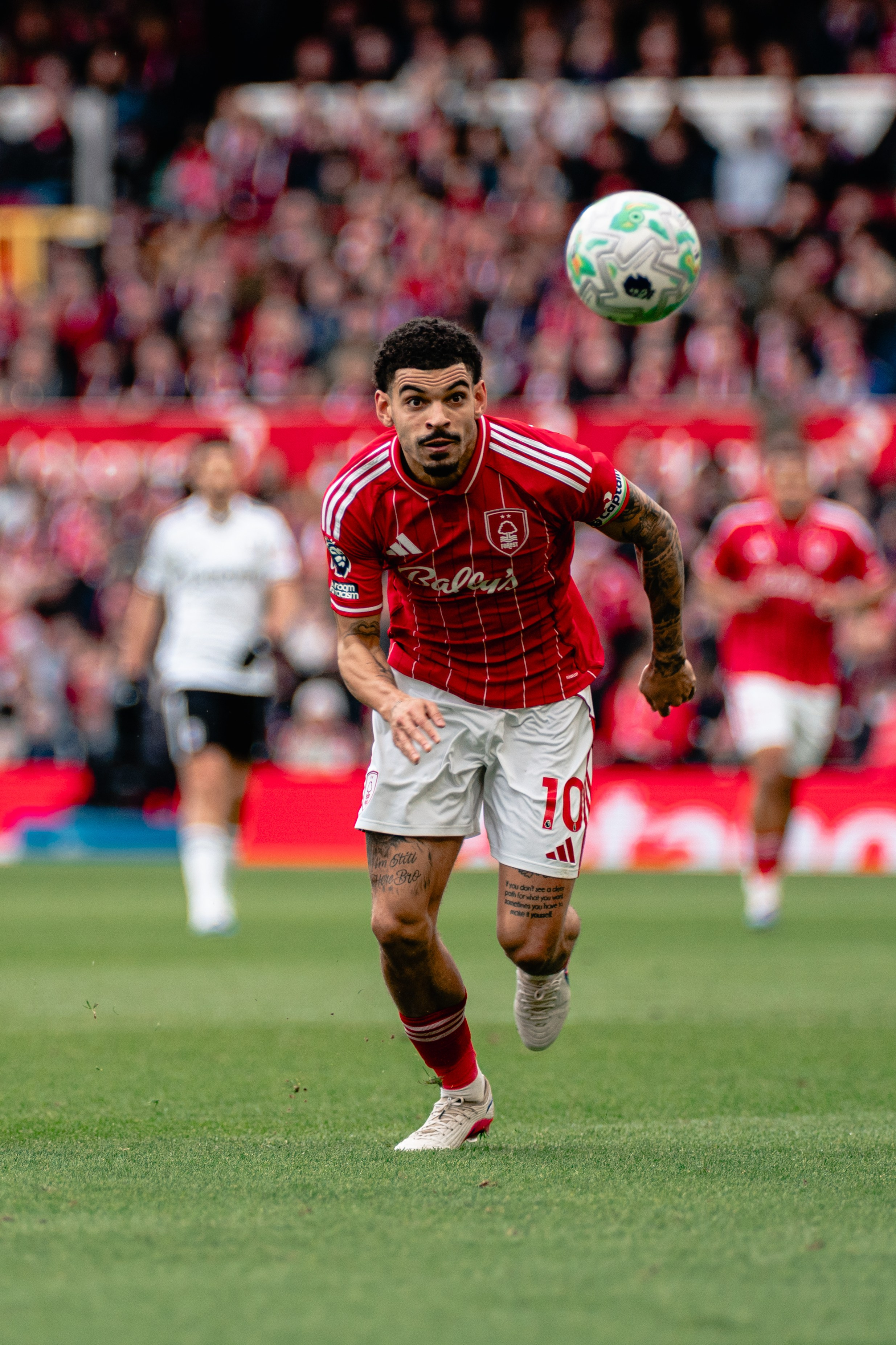 Nottingham Forest player challenging for the ball during a Premier League football match.