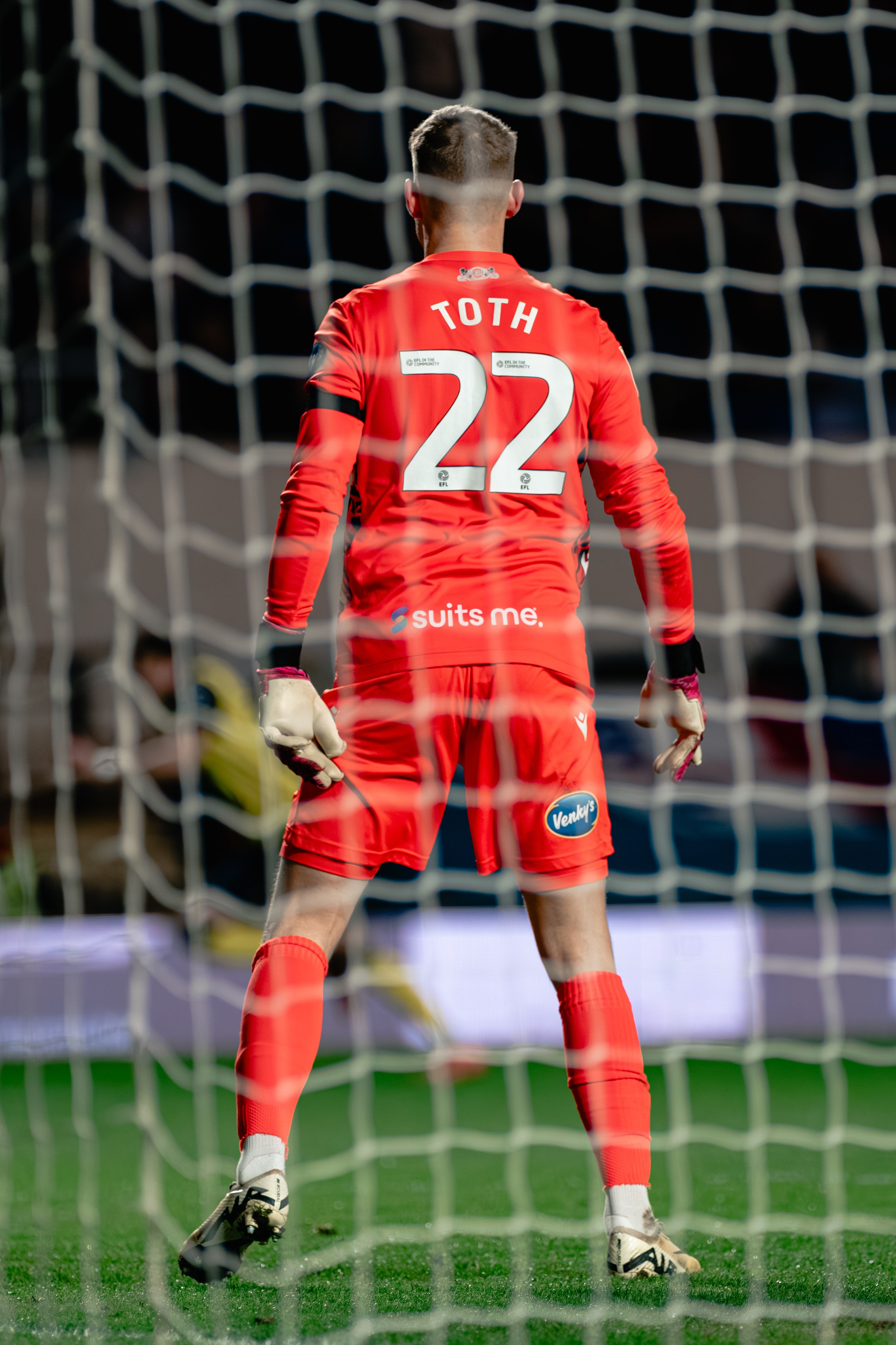 Goalkeeper wearing number 22 standing in front of the net during a professional football match