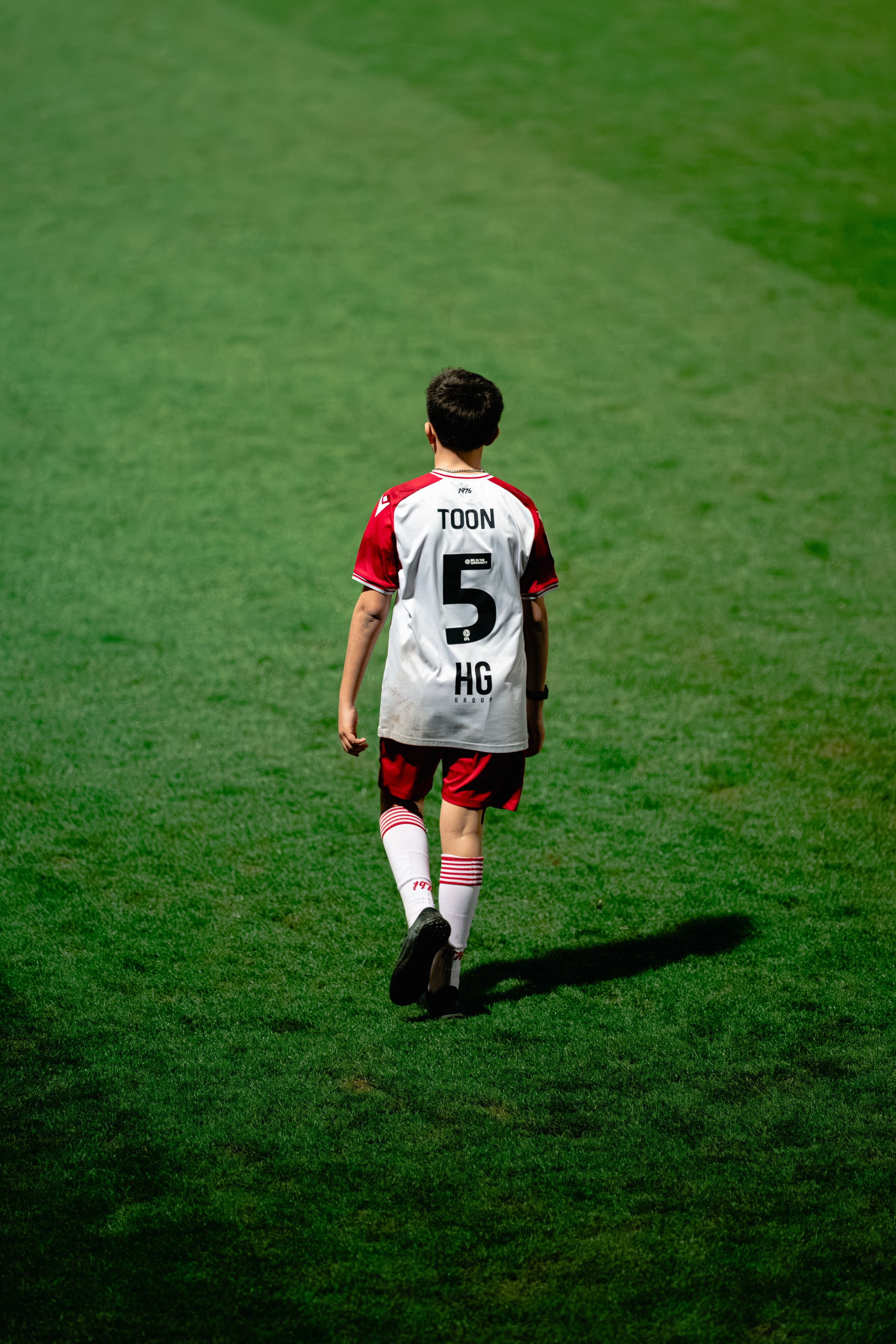 Football supporter wearing number 5 isolated on the pitch during a professional match.