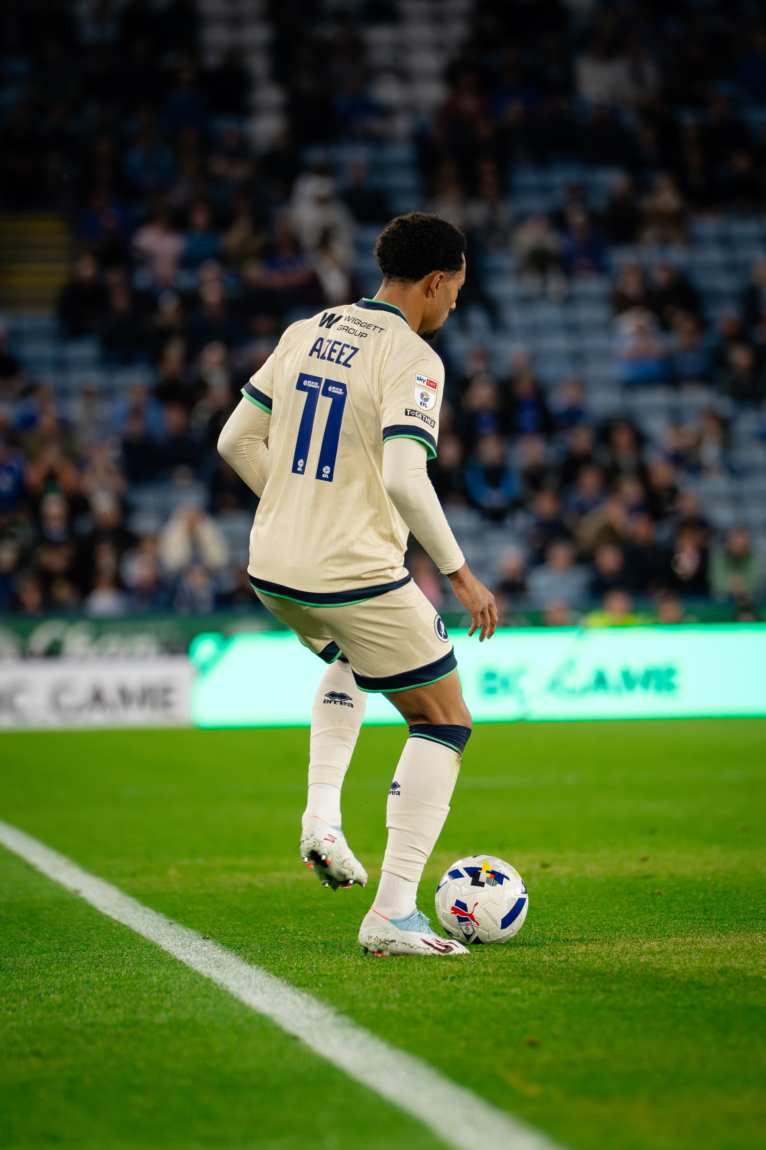 Millwall player wearing number 11 controlling the ball near the touchline during the Championship fixture against Leicester City.