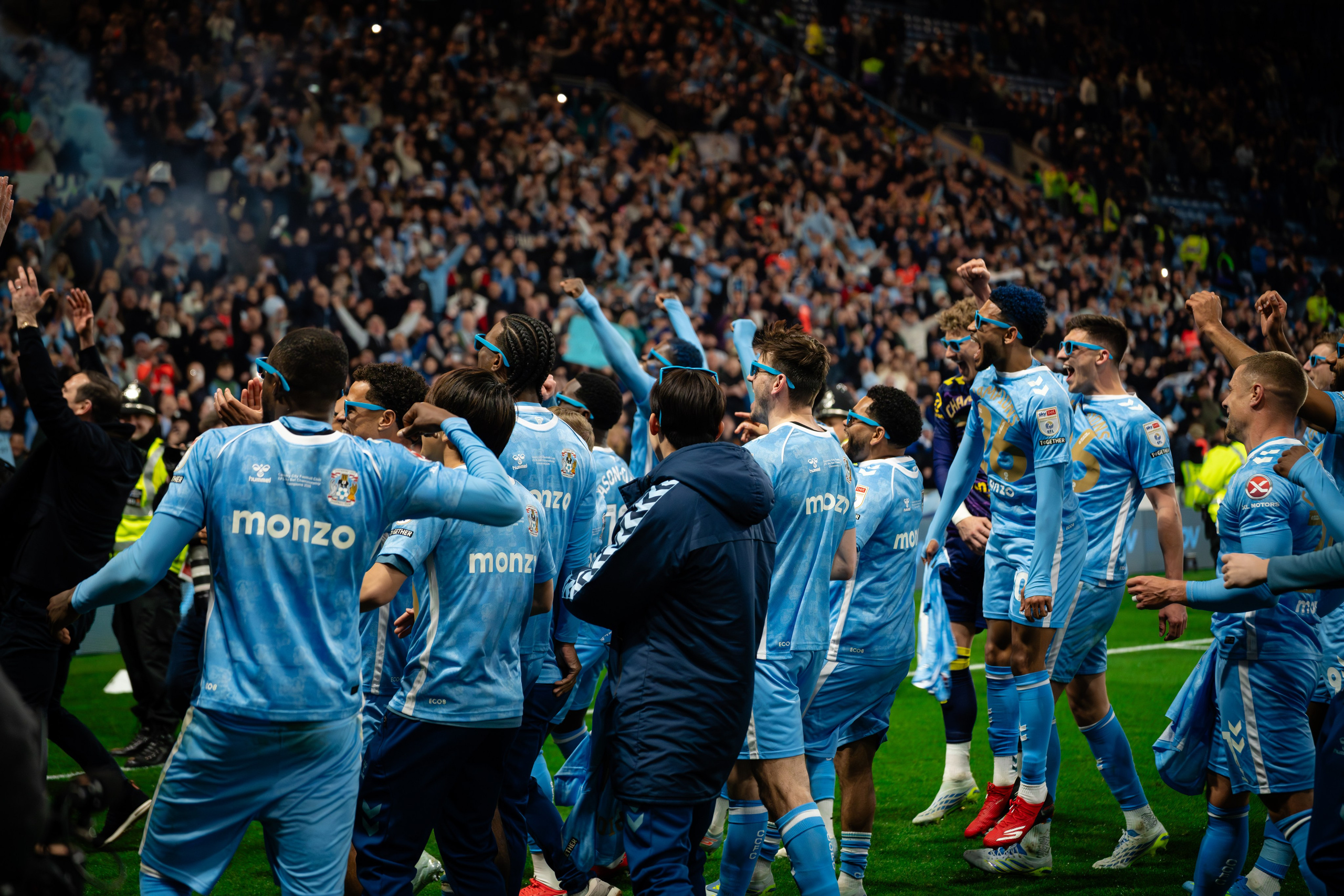 Professional football players gathered together in front of supporters during a match.