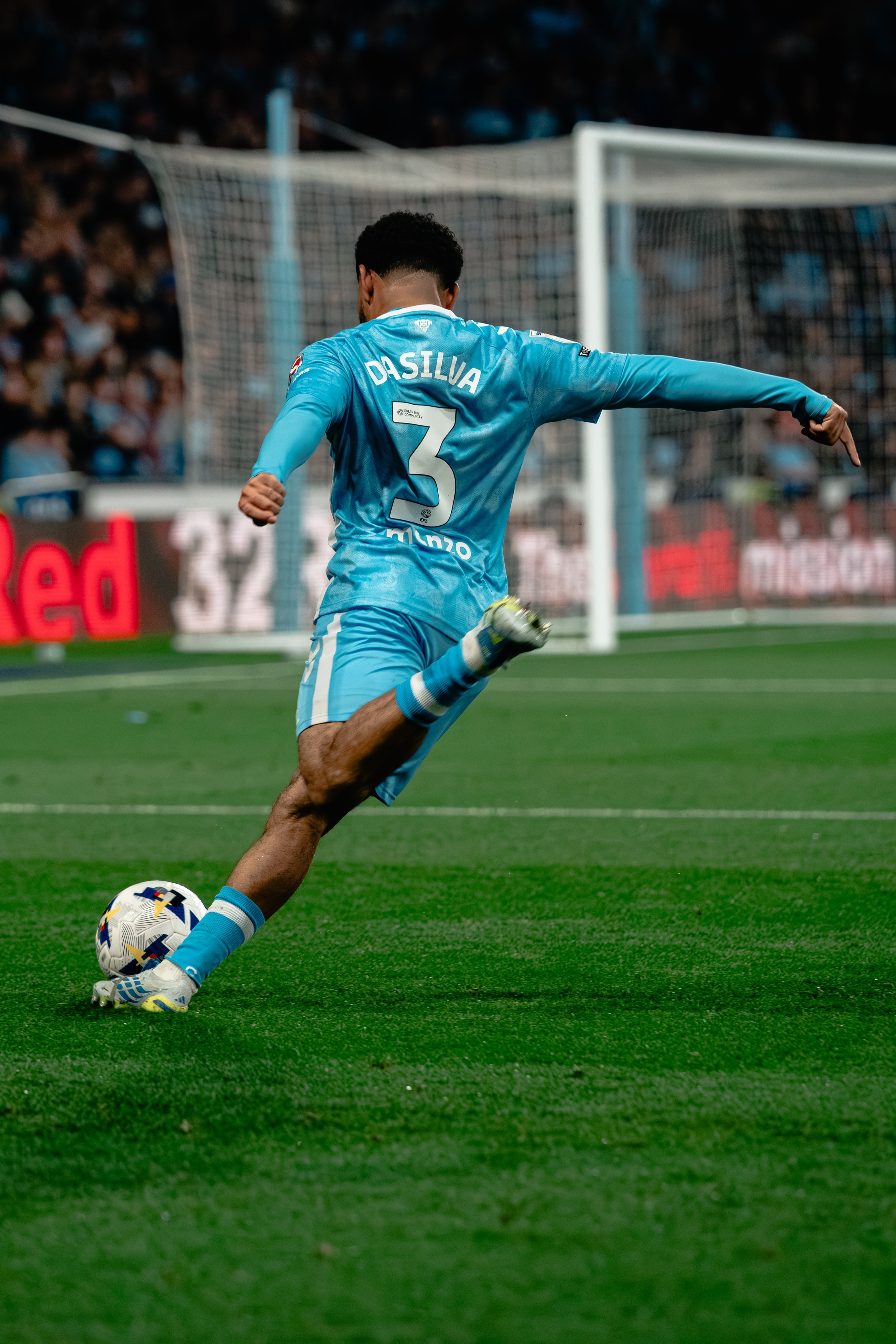 Jay Dasilva striking the ball for Coventry City during a professional football match.