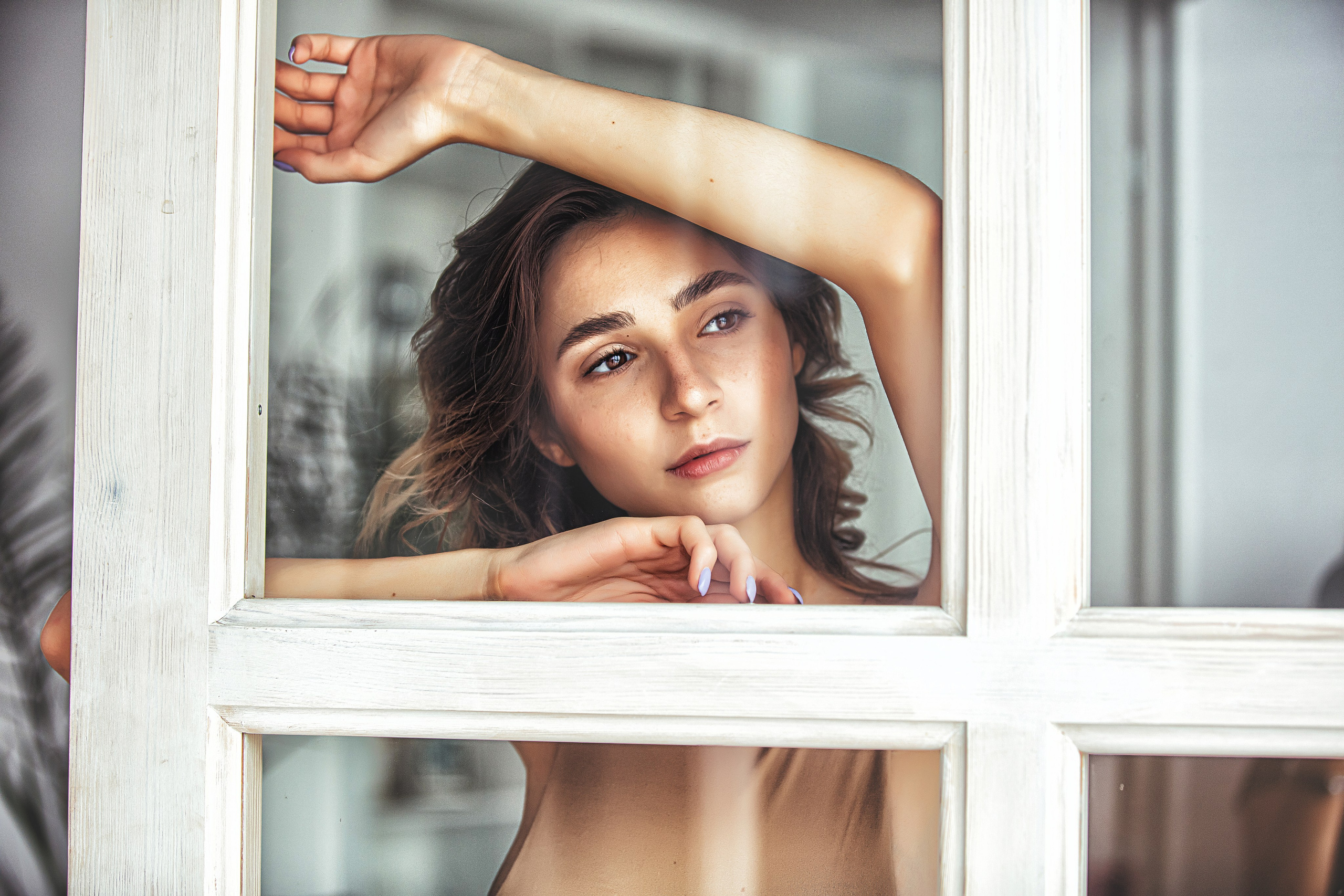 Portrait artistique derrière une vitre – émotion et mystère dans une séance photo créative