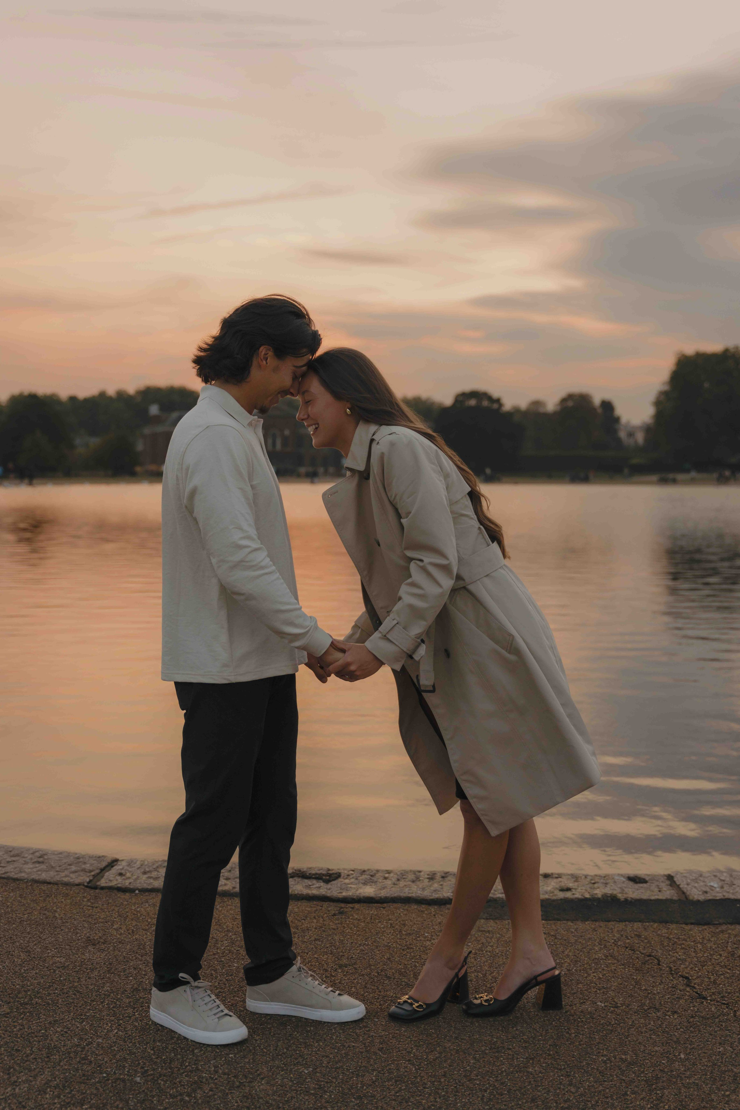 Romantic couple kissing at sunset in Kensington Gardens London engagement
