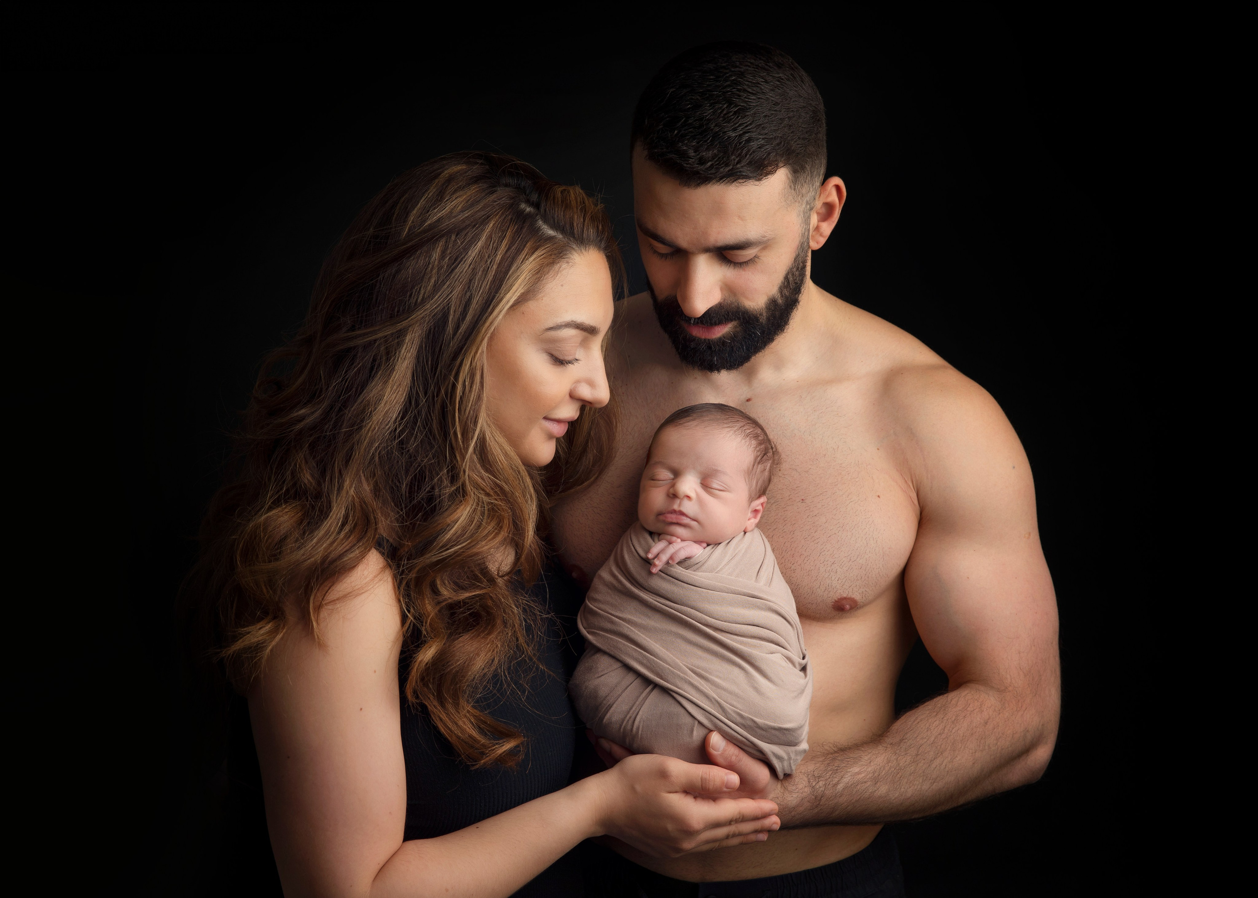 Syskonen håller sin nyfödda bror i famnen, ett fotografi från fototillfället av familjeband och glädje.