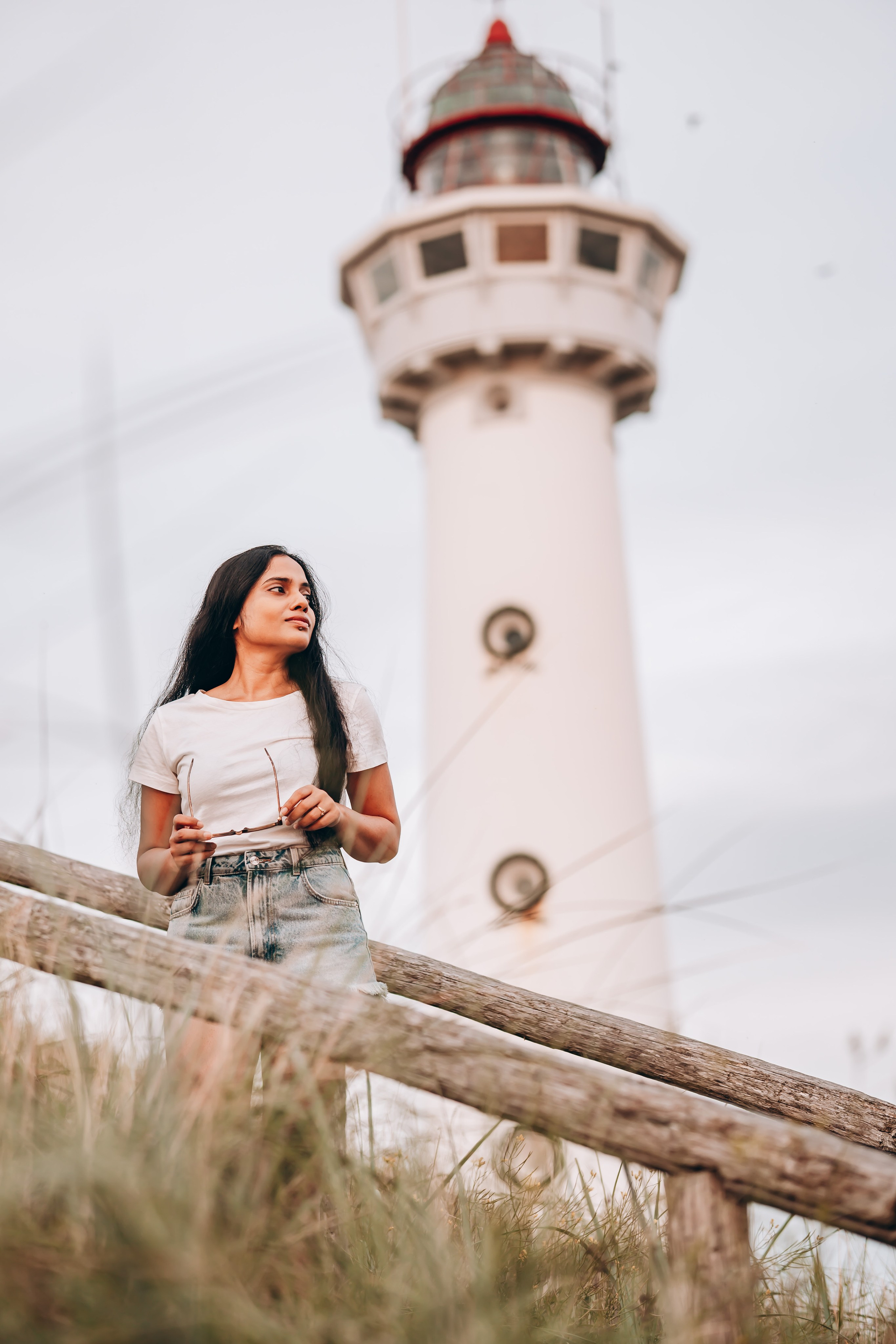 Woman standing in front of a lighthouse in the Netherlands