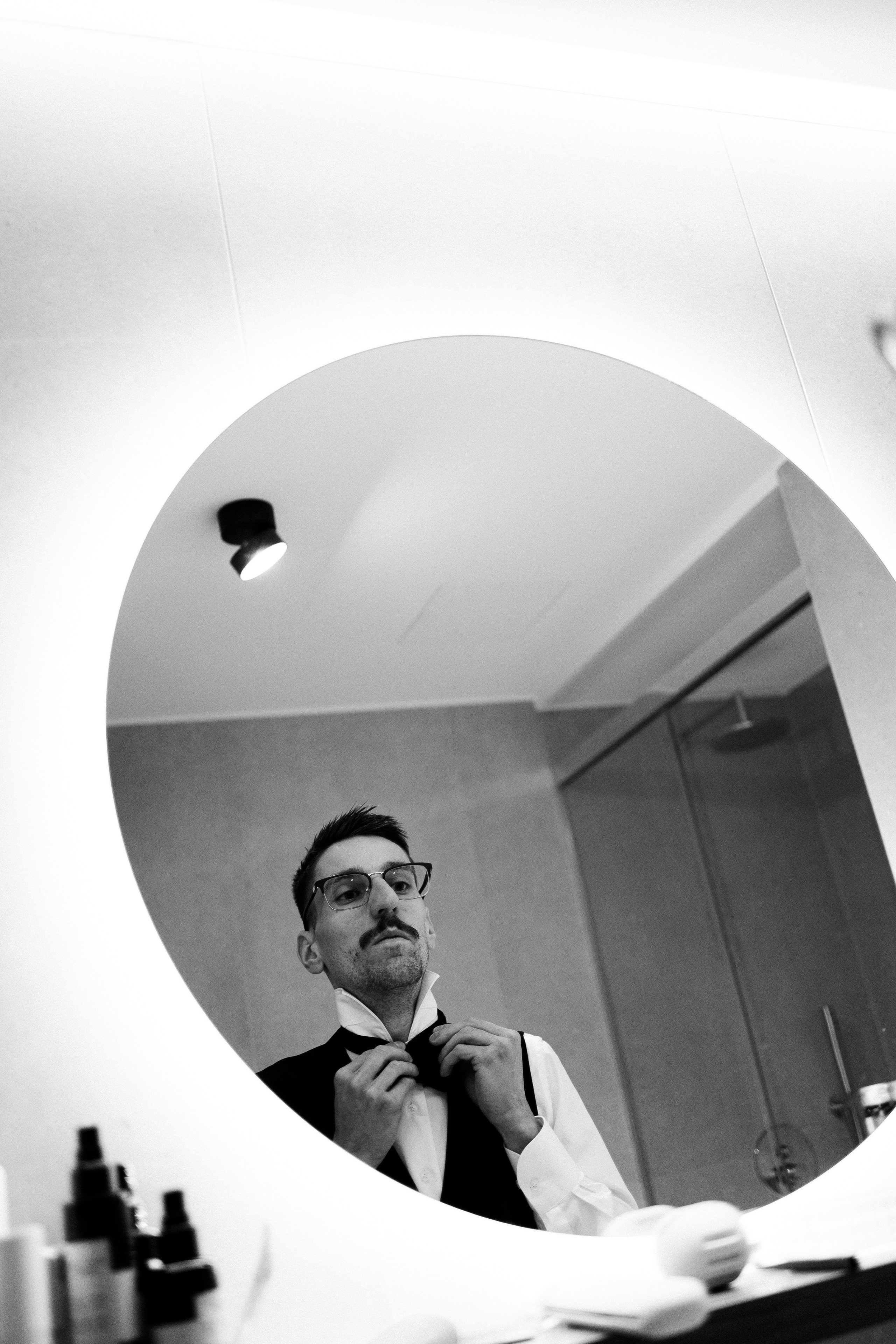 Groom adjusting his bow tie before the wedding on Lake Como