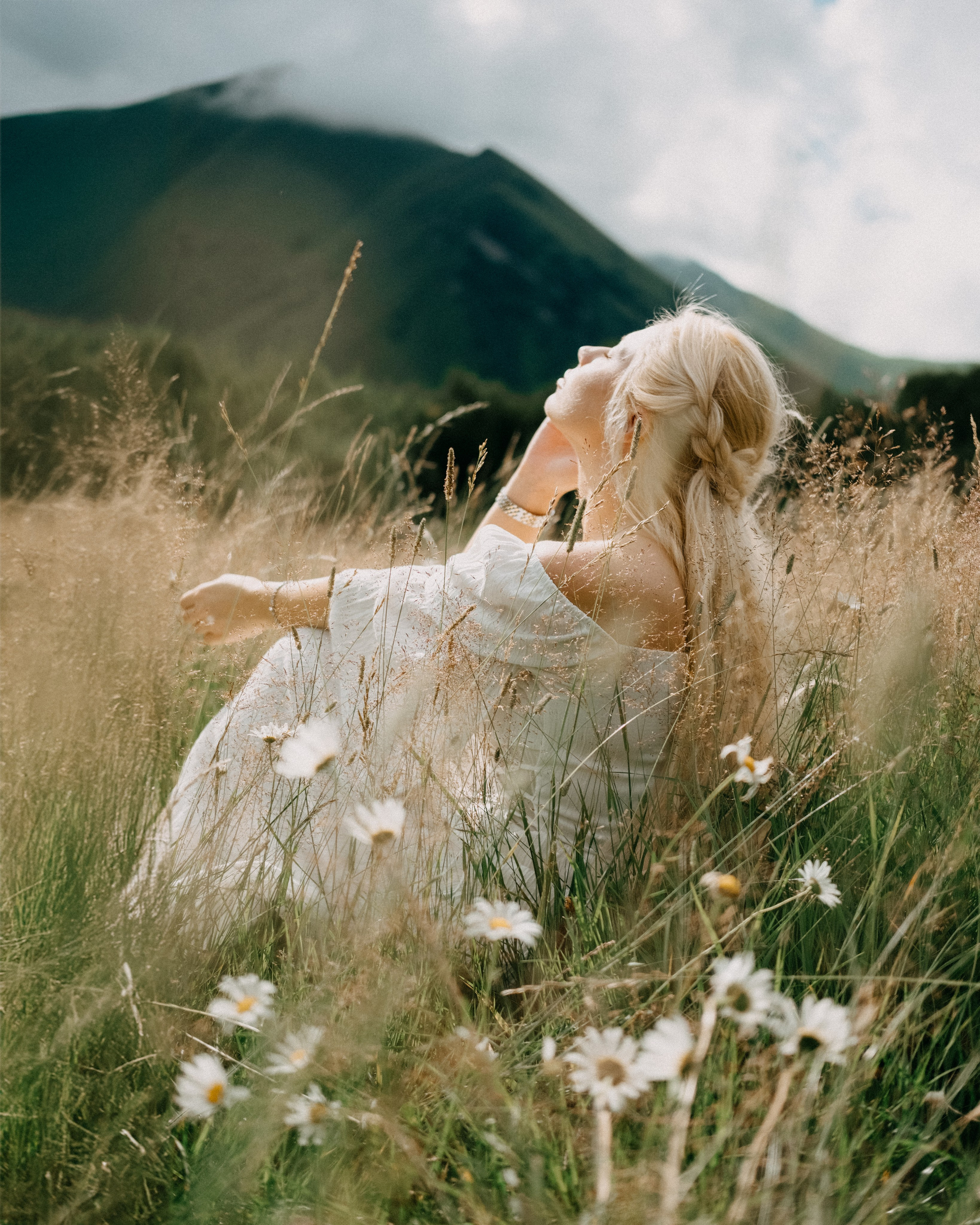 Woman lying in wildflowers in alpine meadow