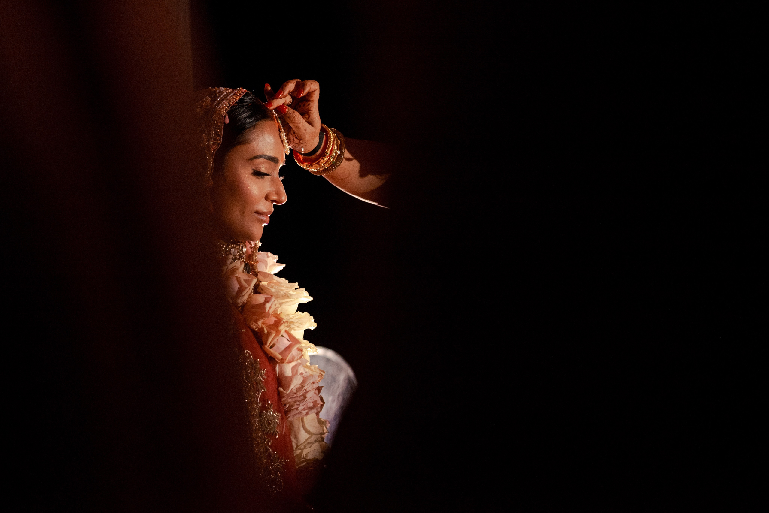 Close up of Indian bride receiving blessing on her forehead from her mother during Kanya Aagman ceremony in Cancun