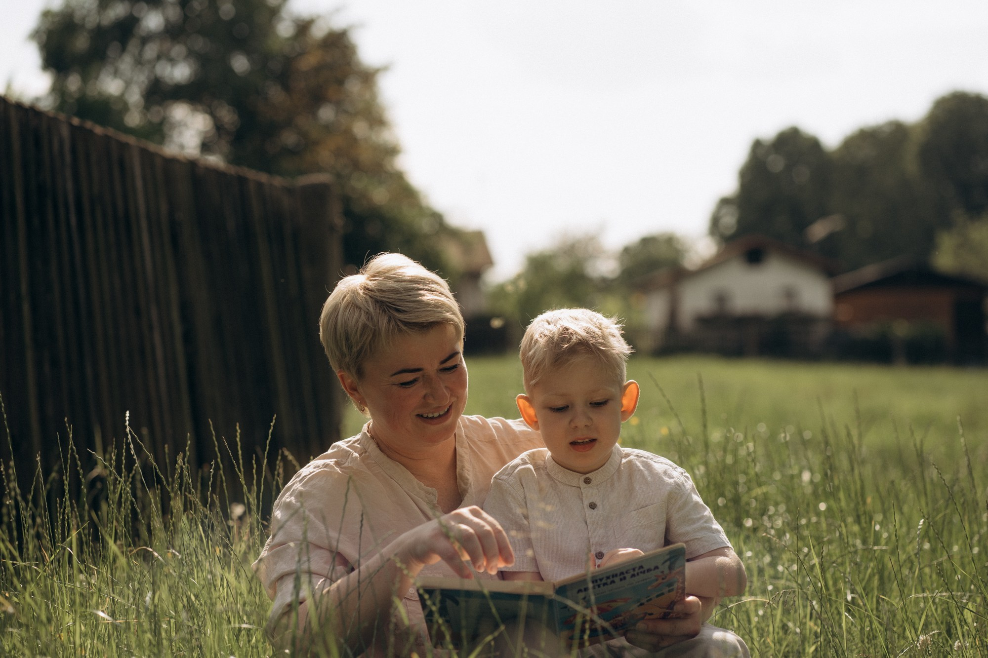 Мама и сын читают книгу на траве – семейная фотосессия, уютные детские фотографии