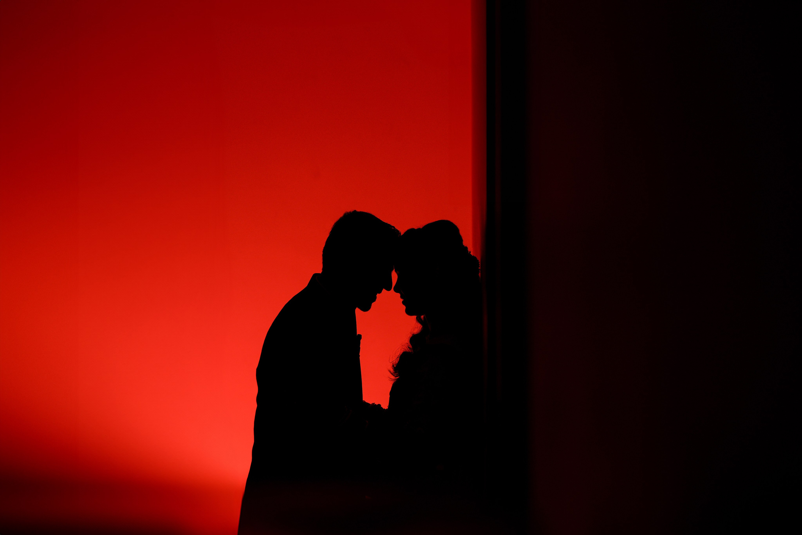 dramatic red-lit studio silhouette portrait of a couple with foreheads touching in Malleshwaram, Bengaluru