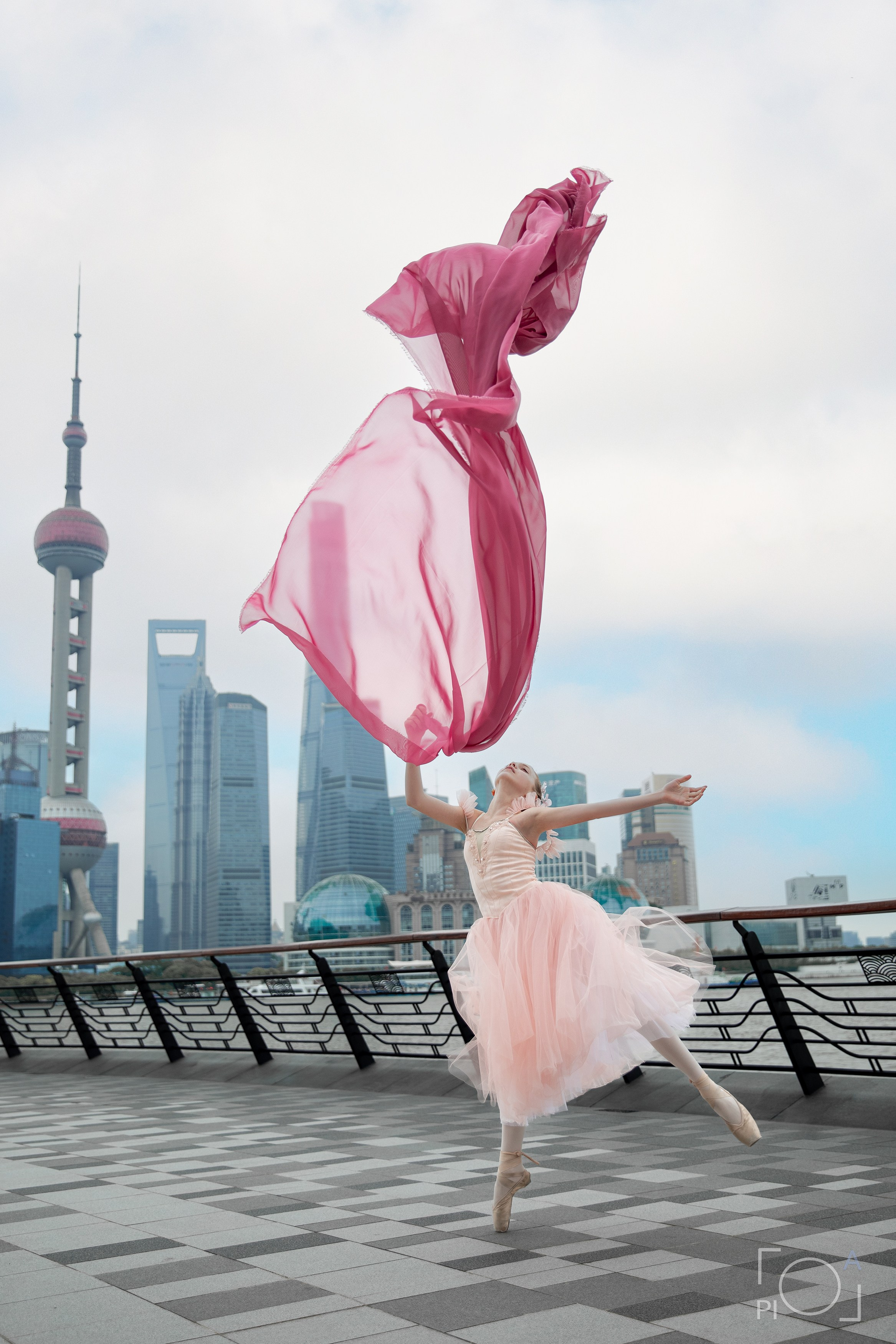Фотосессия в Шанхае для девочки 11 лет. Маленькая балерина в розовом платье с пышной длинной пачкой и малиновой развивающейся тканью, танцует на набережной в Шанхае с видом на Lujiazui