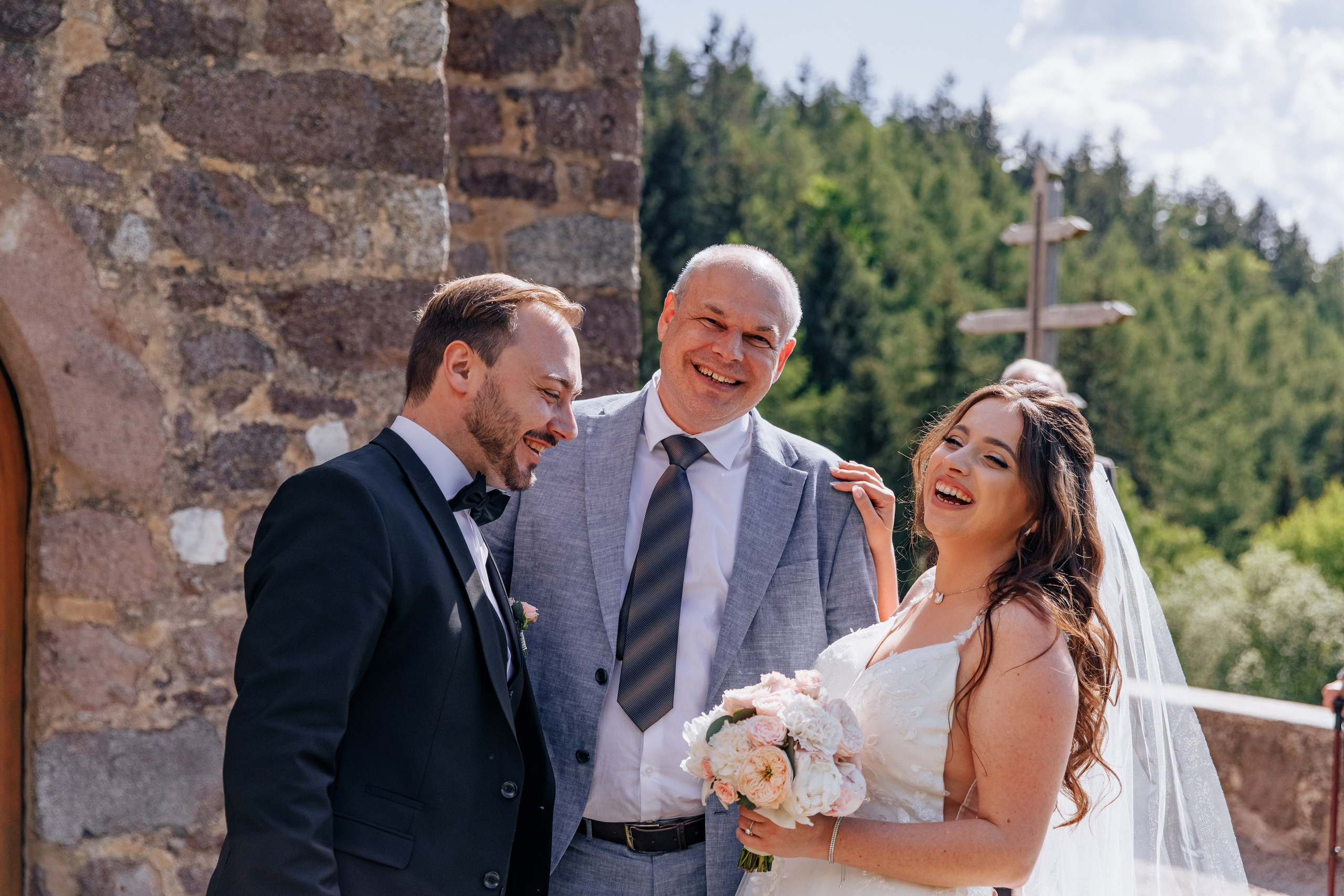 Der Bräutigam und die Braut lachen zusammen mit ihren Gästen während der Hochzeitsfeier.