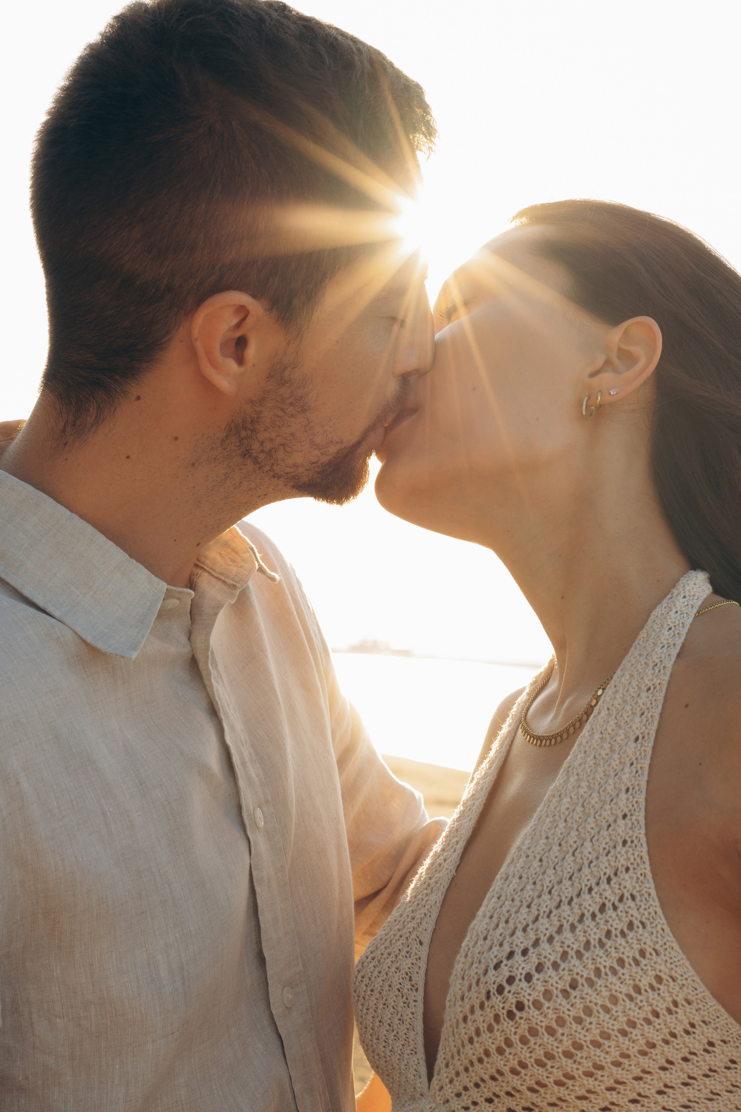 coppia che si bacia al tramonto sul mare durante una love story a Rimini