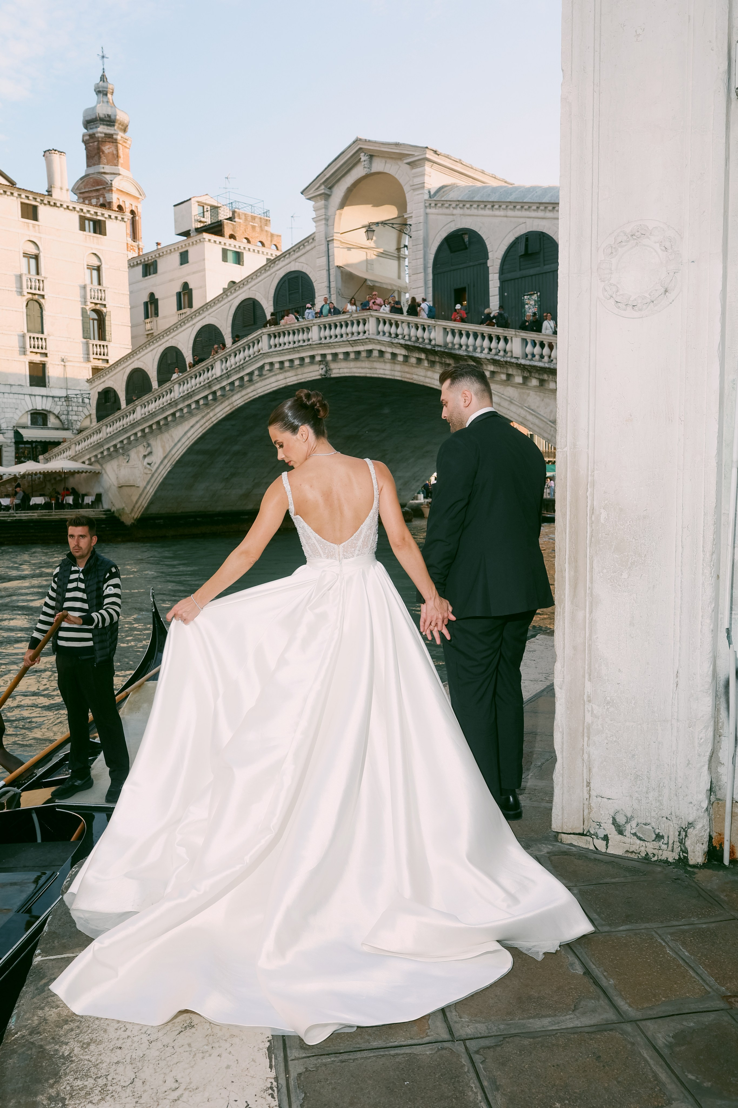 Romantic moment of a wedding couple by the Rialto Bridge on the canals of Venice