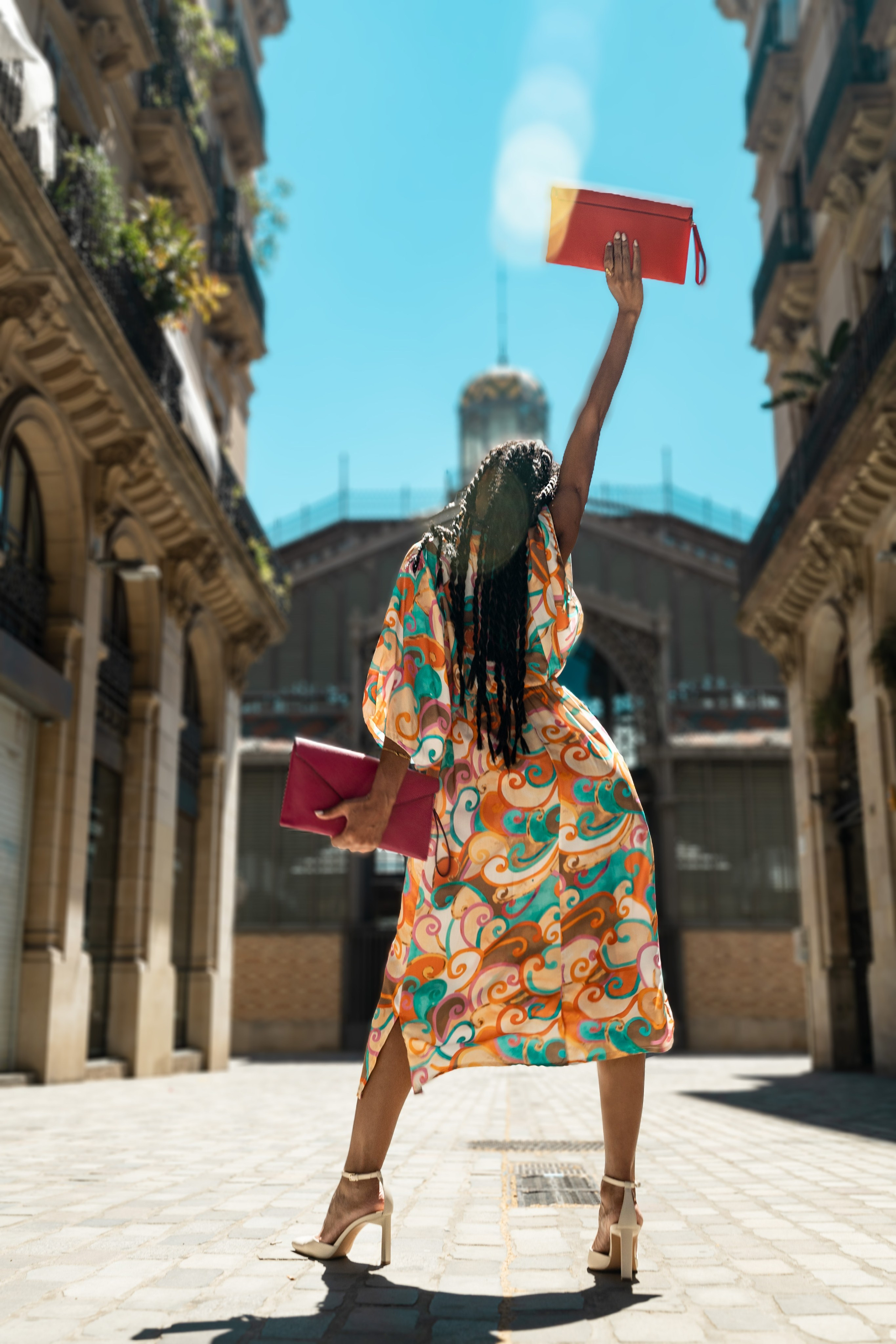 Modelo con un bolso estampado junto a una pared azul